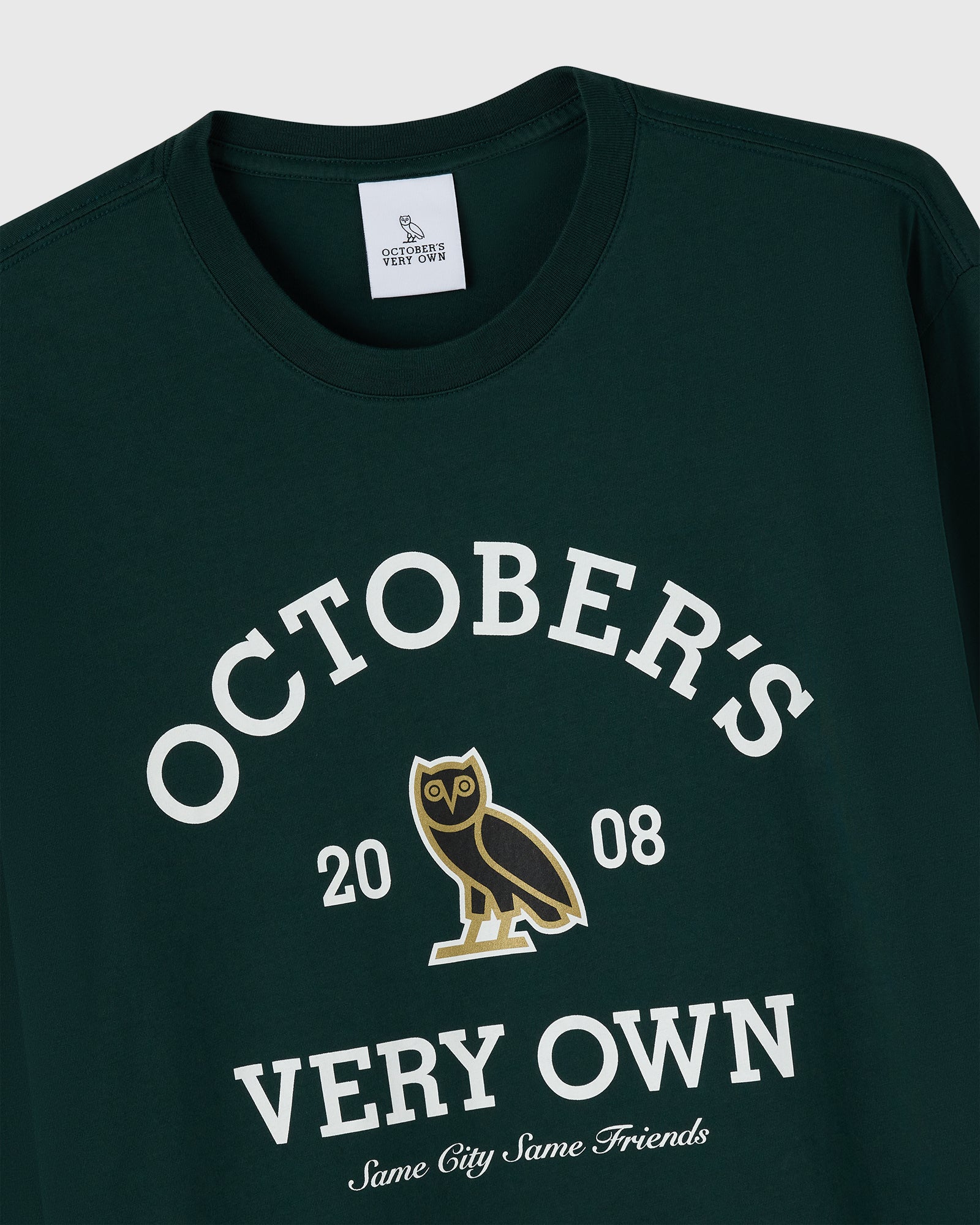 Midnight green long-sleeve tee with white text reading "October's Very Own," gold owl graphic, and "20 08" printed on chest.