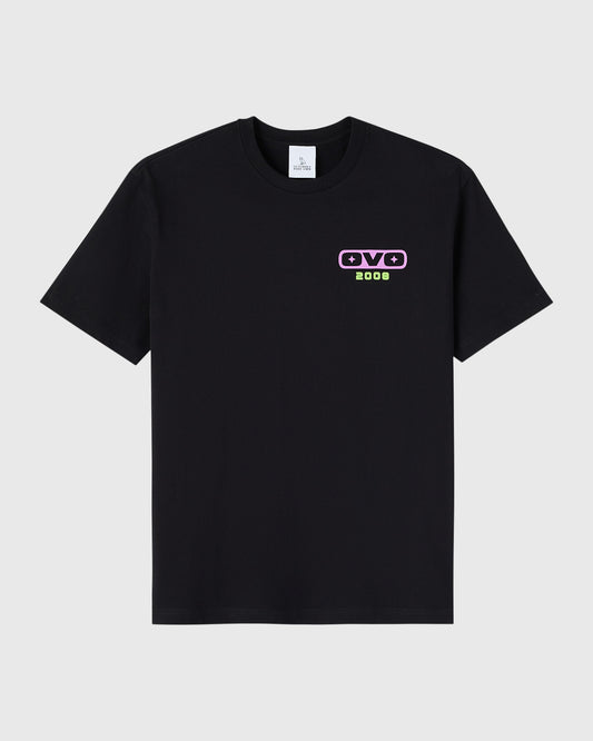 Black crewneck t-shirt with small purple and green graphic print on chest.