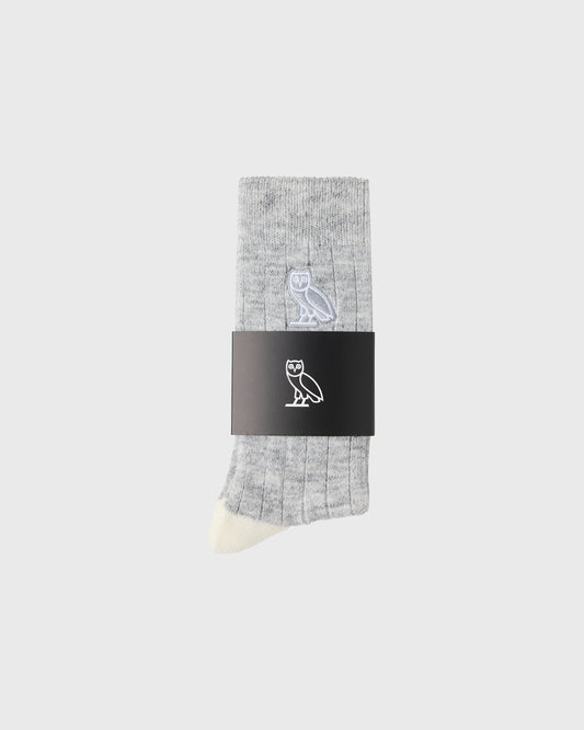 Gray crew sock with white owl logo and cream-colored toe, displayed with black brand label band.