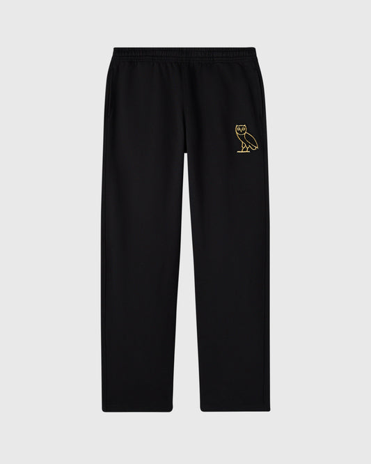 Black sweatpants with elastic waistband and open hem, featuring gold owl embroidery on right thigh.
