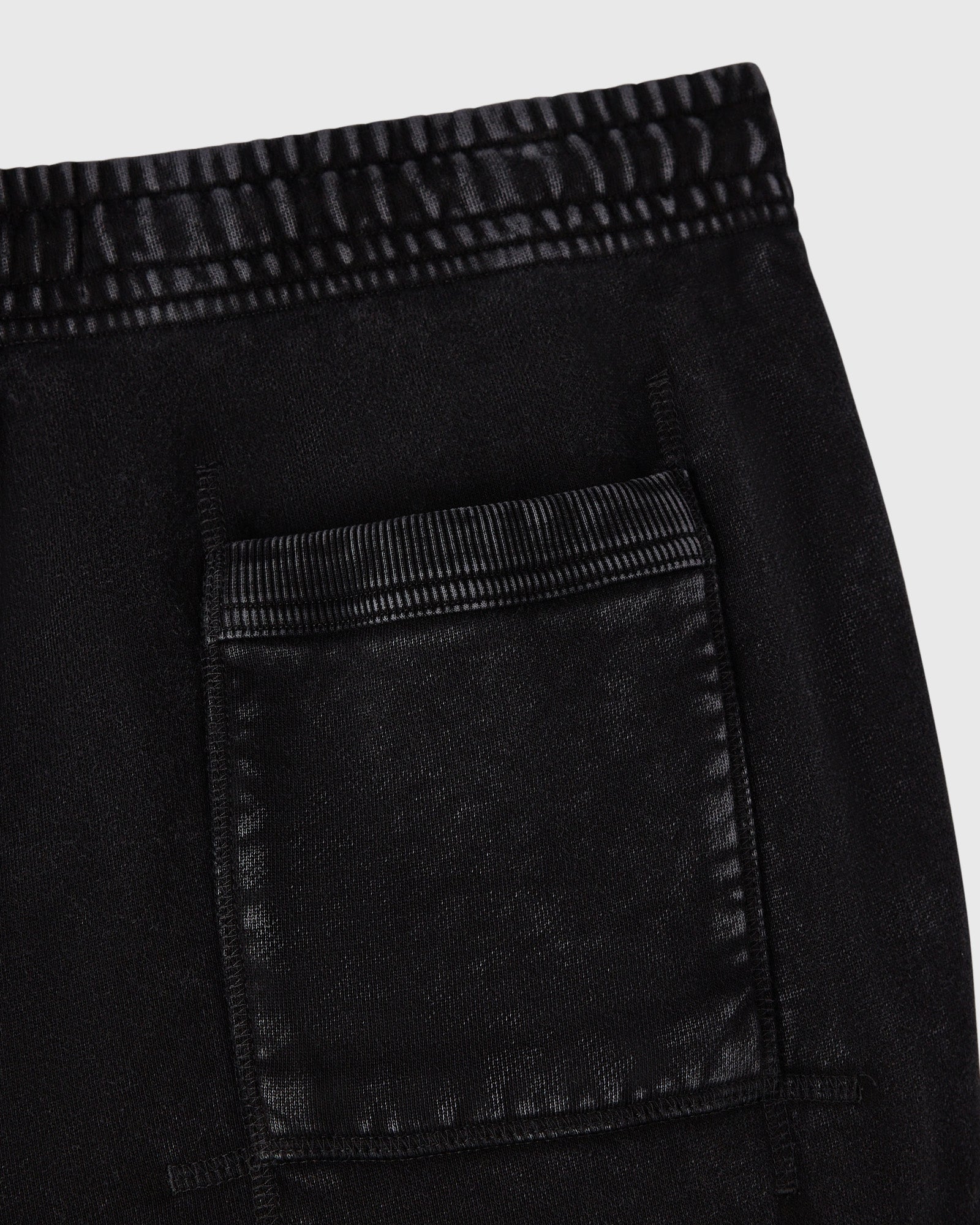 Black sweatpant with striped elastic waistband and patch pocket detail.