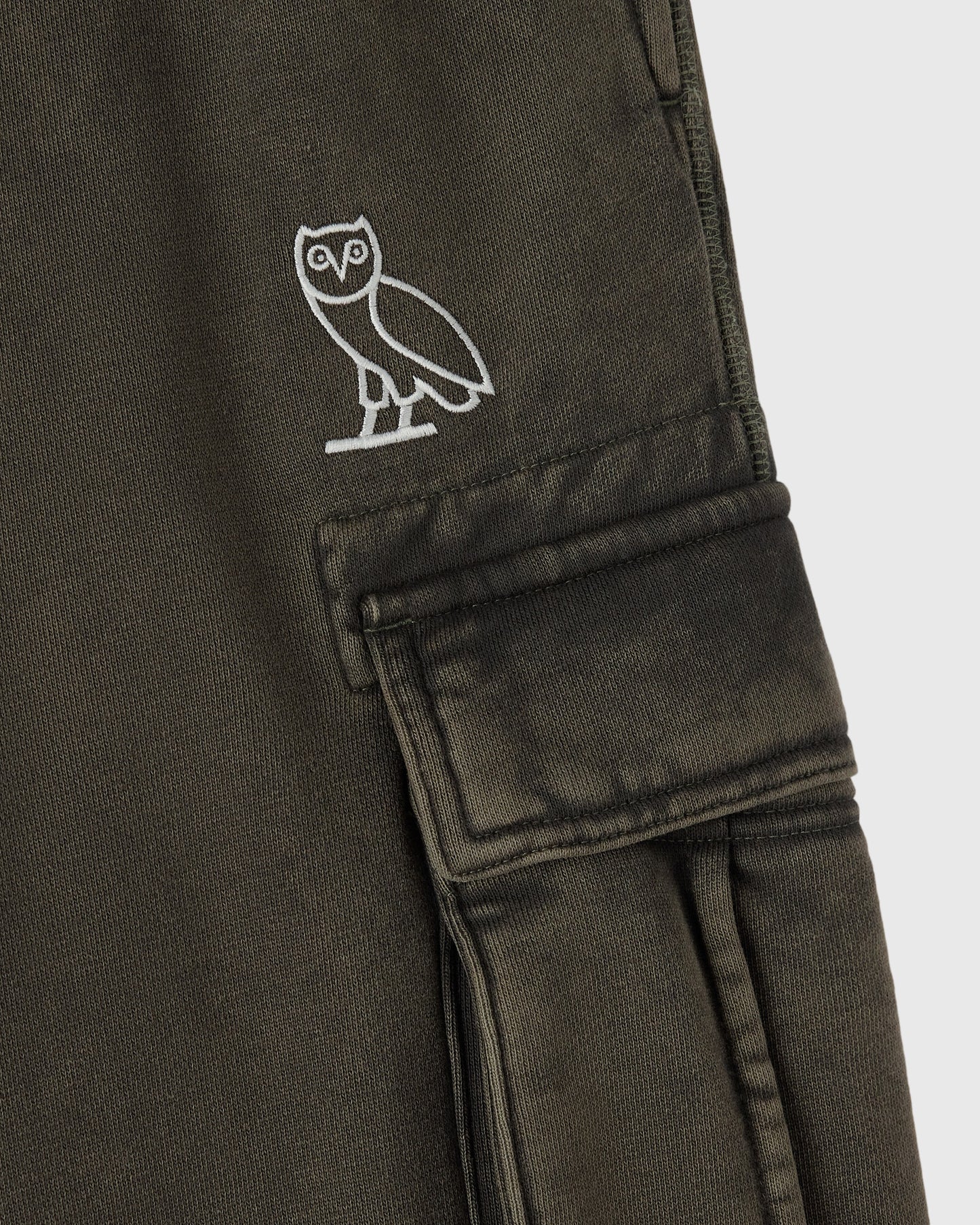 Deep olive cargo sweatpant with white owl embroidery on thigh and utilitarian patch pocket.