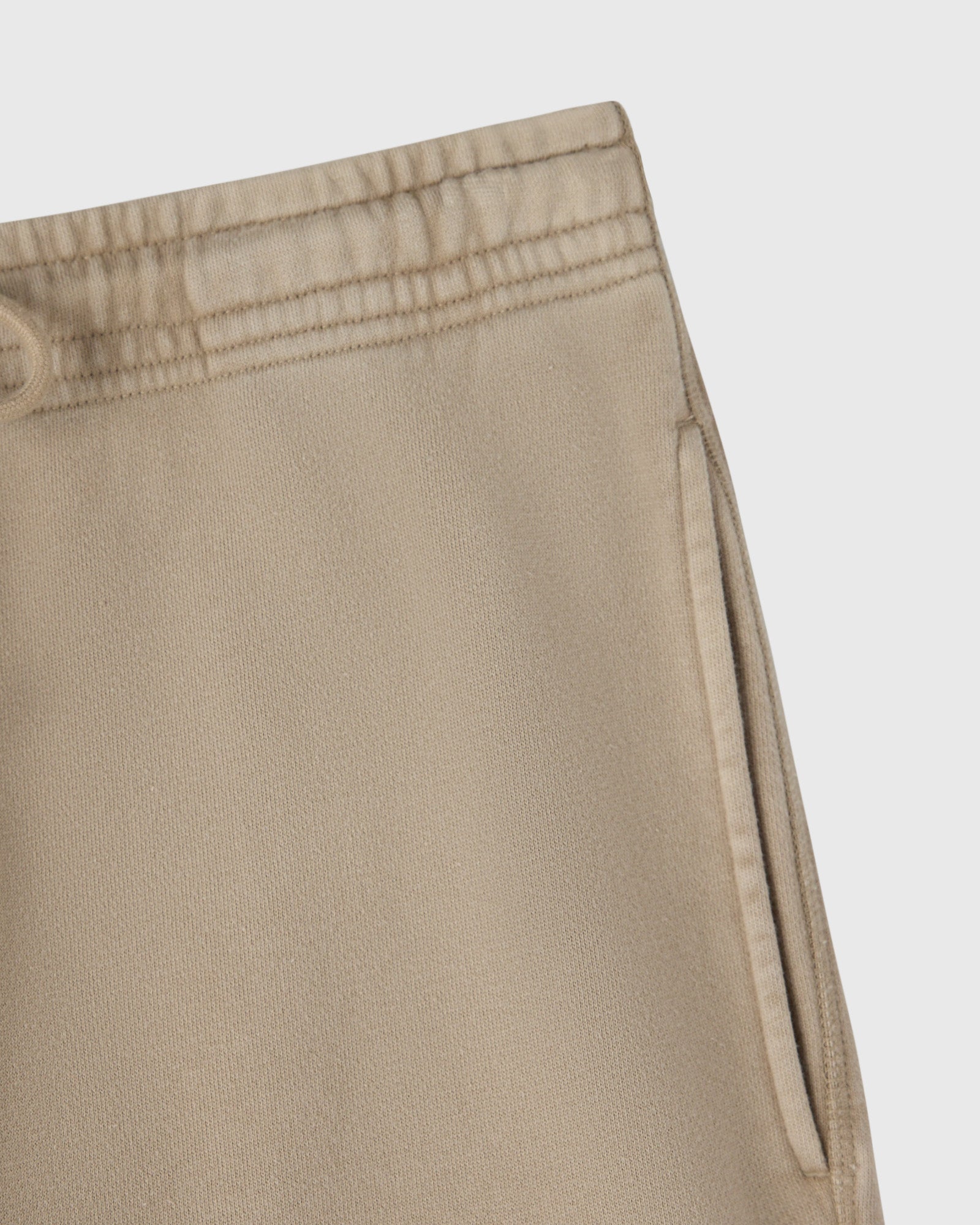 Sandstone sweatpant with elastic waistband and side cargo pocket detail.