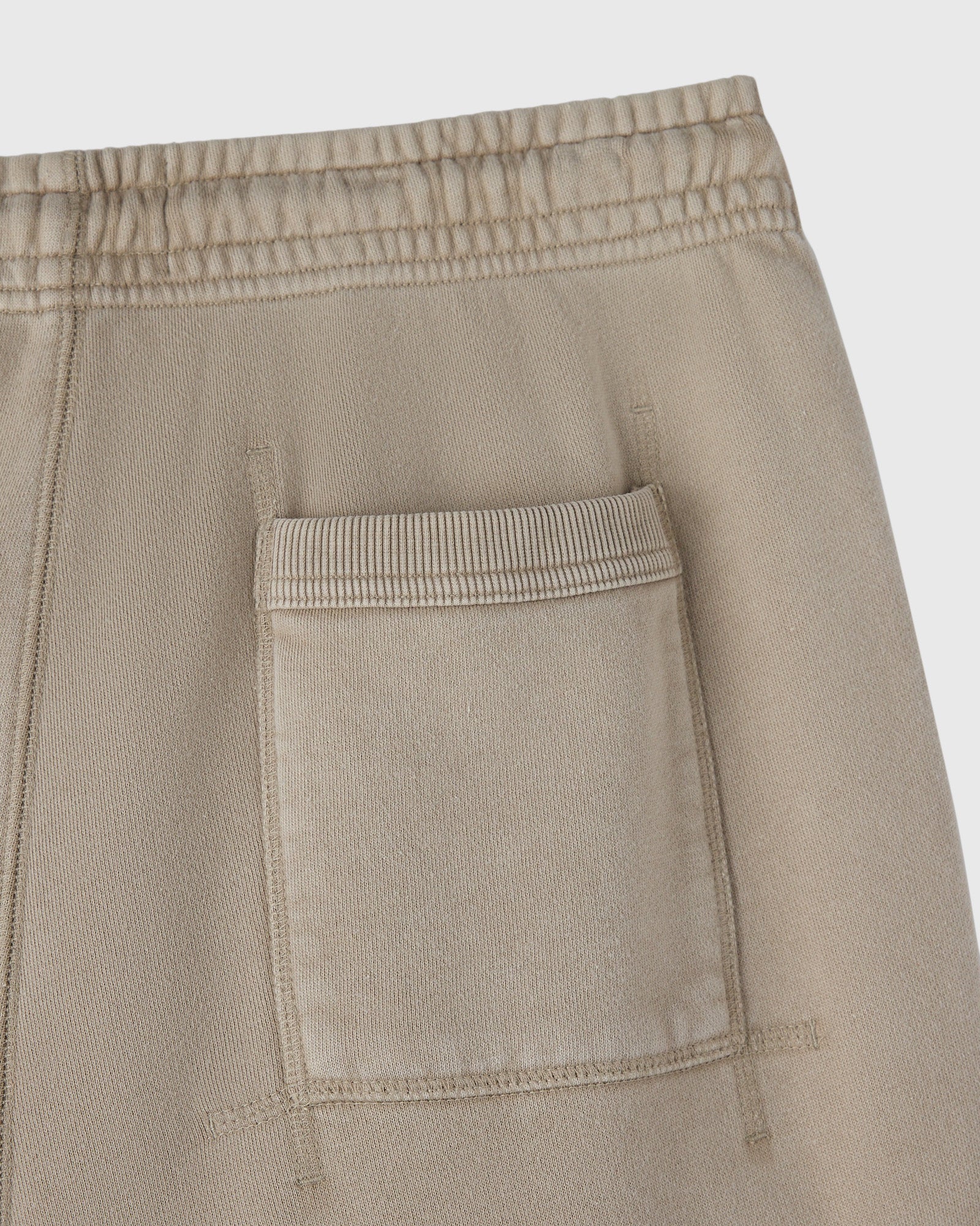 Sandstone sweatpant with elastic waistband and front patch pocket detail.