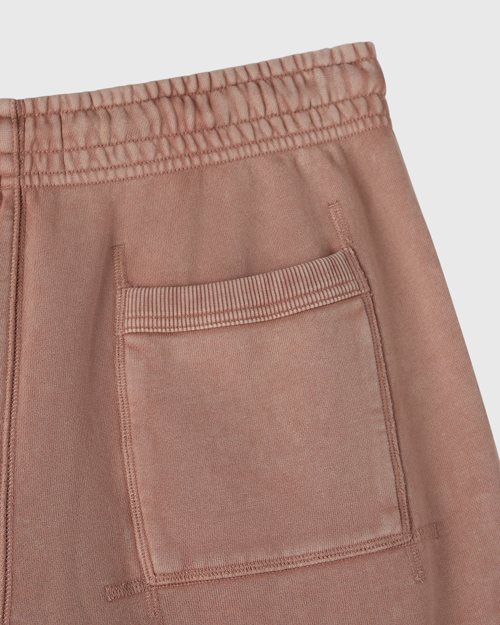 Clay pink sweatpant with elastic waistband and front patch pocket detail.