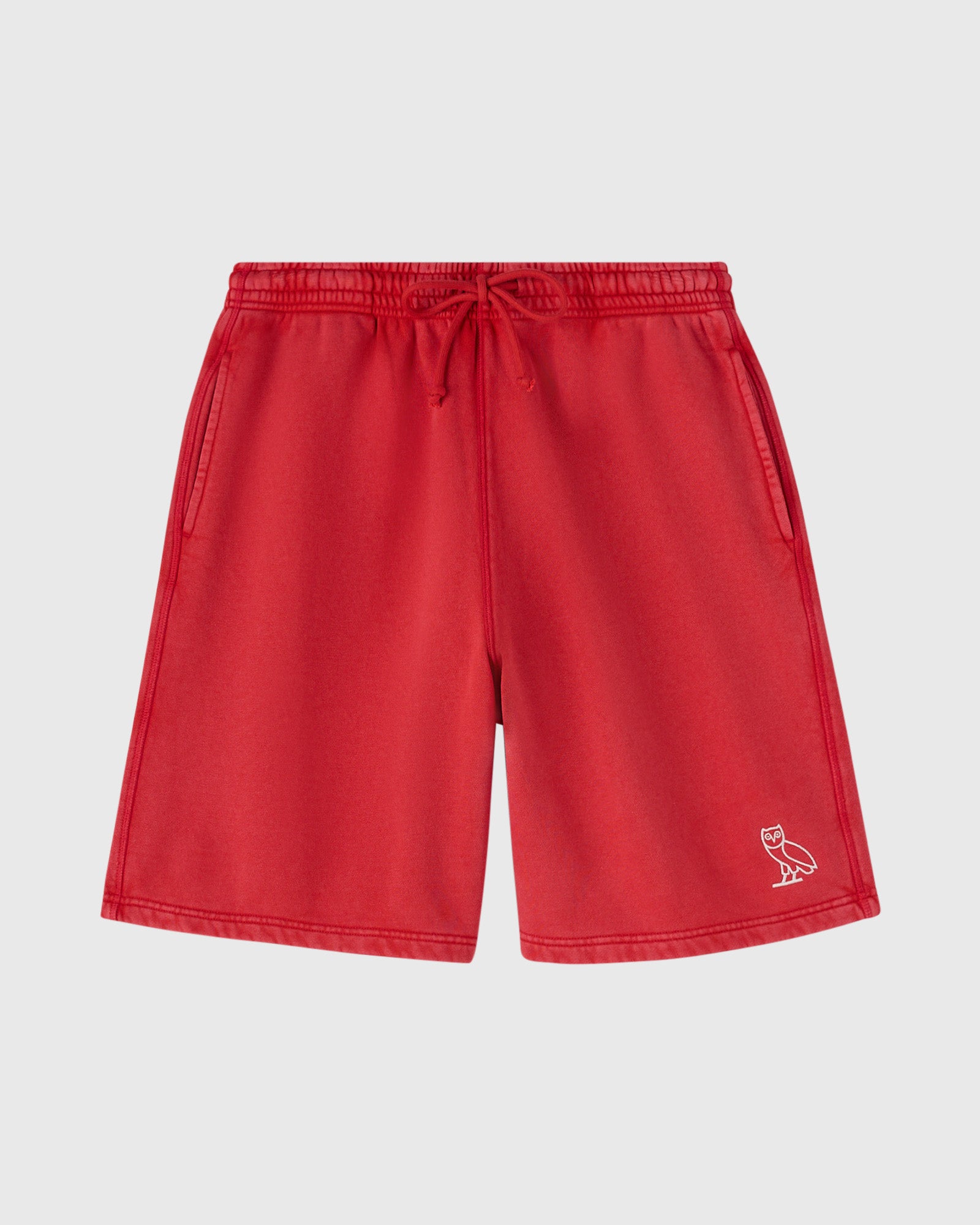 Berry red sweatshorts with elastic waistband, drawstring, side pockets, and small owl logo on lower leg.