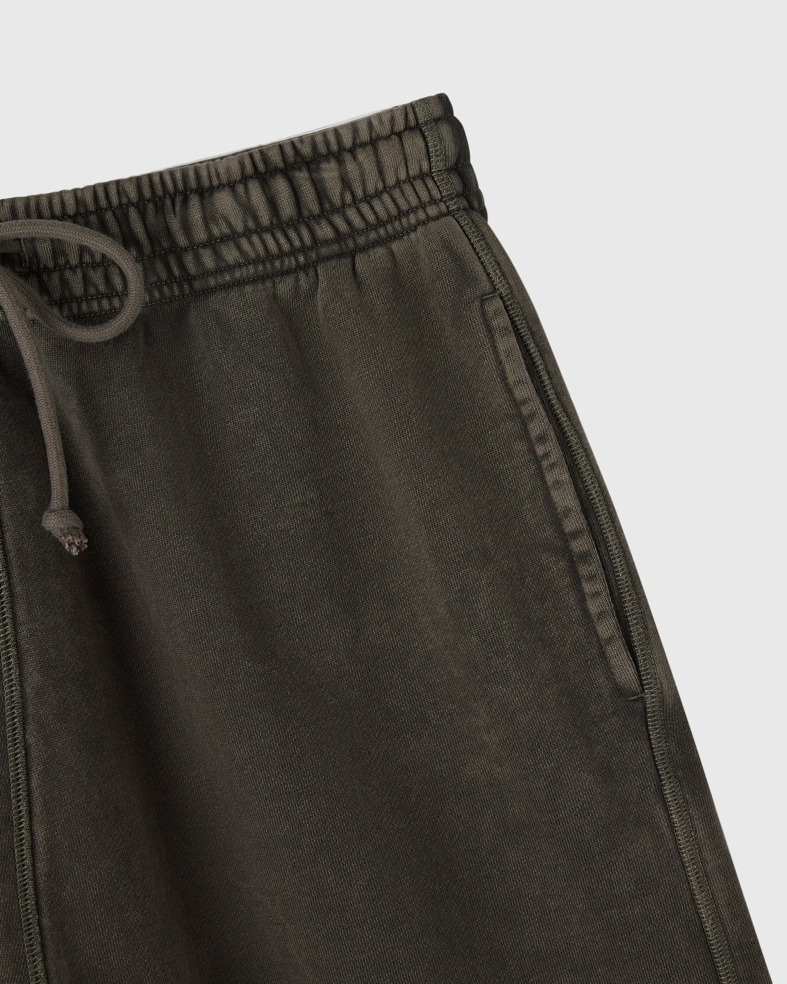 Deep olive sweatshorts with elastic waistband, drawstring, and side seam stitching detail.