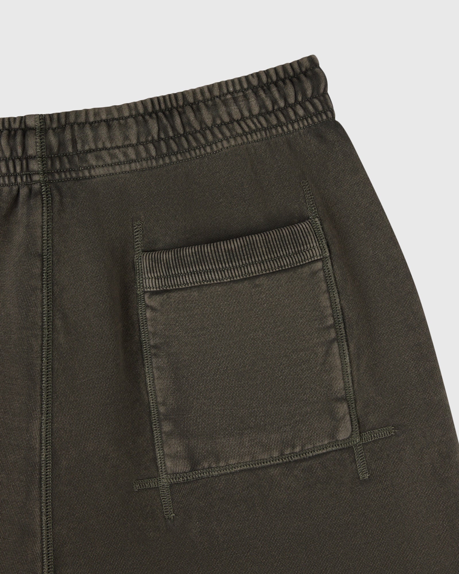 Deep olive sweatshorts with elasticated waistband and front patch pockets with visible stitching detail.