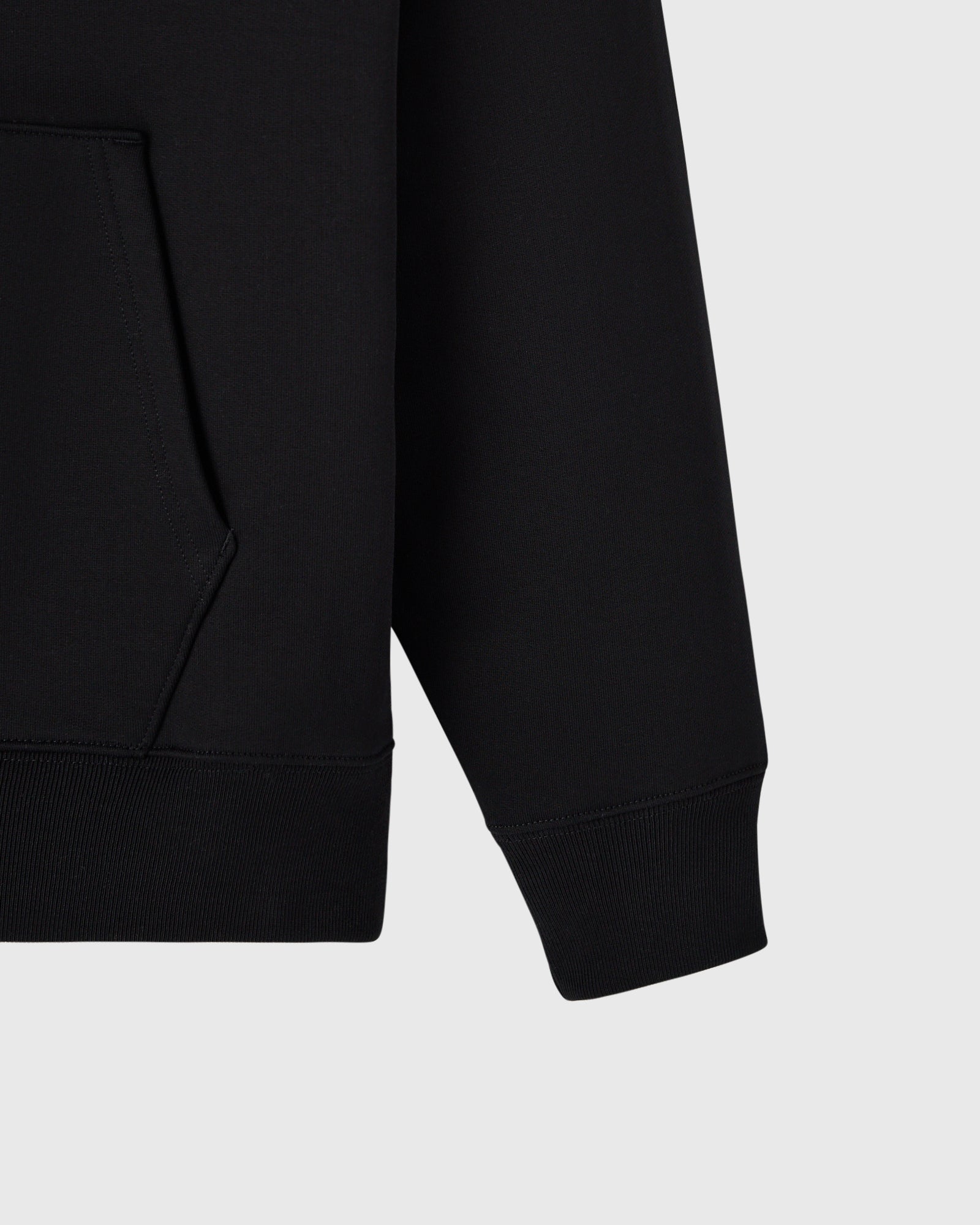 Black hoodie with ribbed cuffs and kangaroo pocket visible on left side.