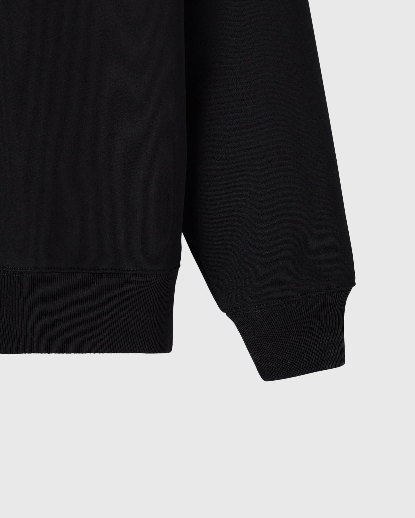 Black quarter-zip mockneck with ribbed cuffs and hem detail.