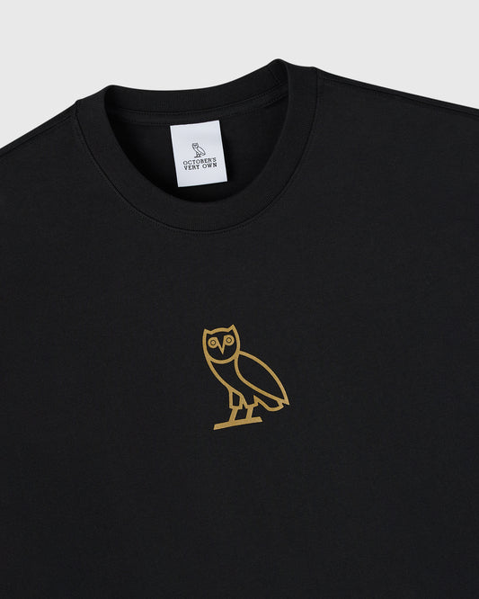 Black crewneck t-shirt with gold owl graphic on chest and brand label on neckline.
