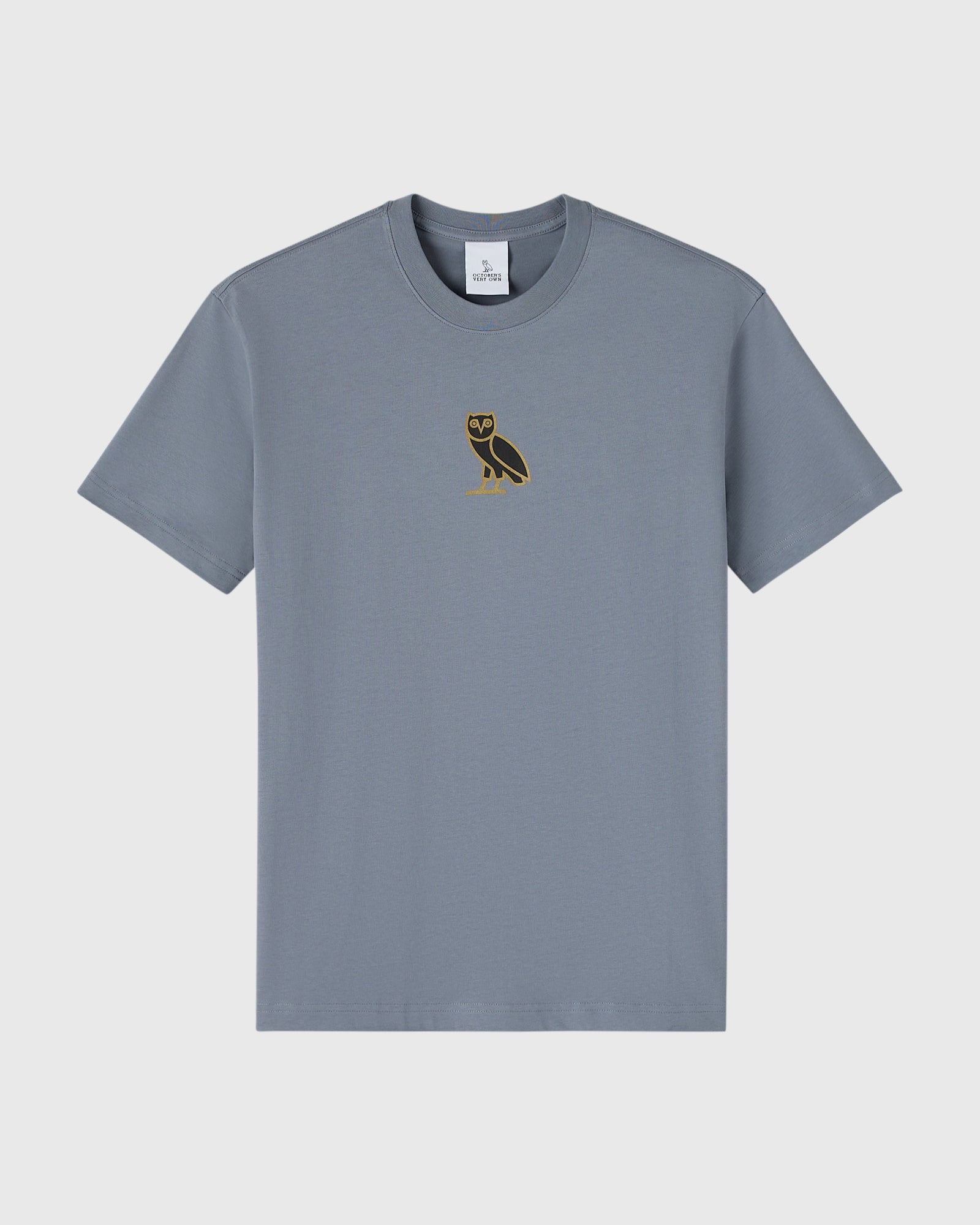 Slate blue crew neck t-shirt with small gold owl embroidery on chest.