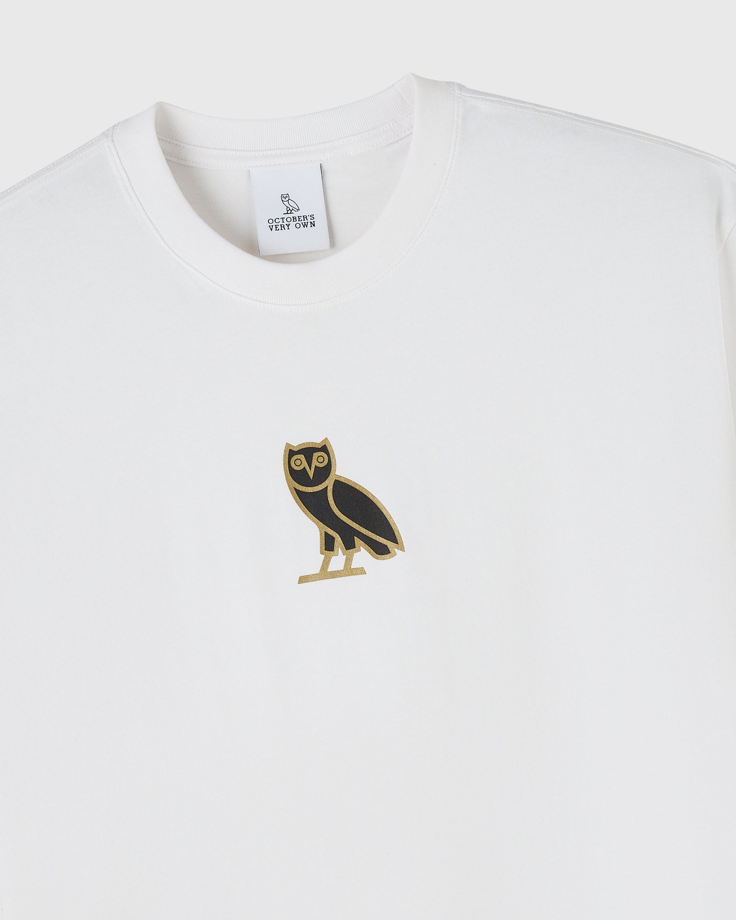 White crewneck t-shirt with black and gold owl graphic on chest and brand label at neckline.