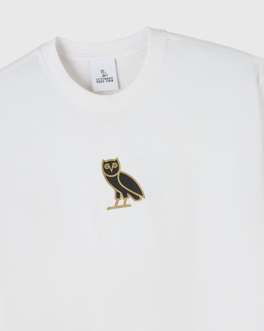 White crewneck t-shirt with black and gold owl graphic on chest and brand label at neckline.
