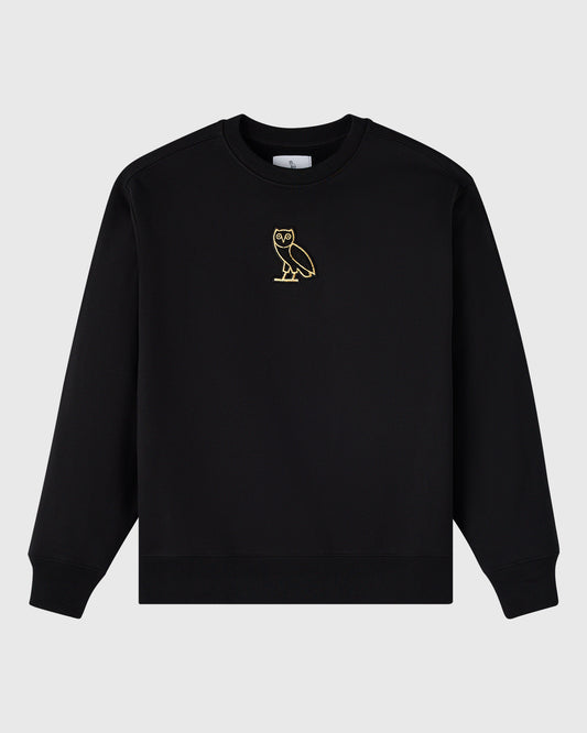 Black crewneck sweatshirt with small gold owl embroidery on chest.