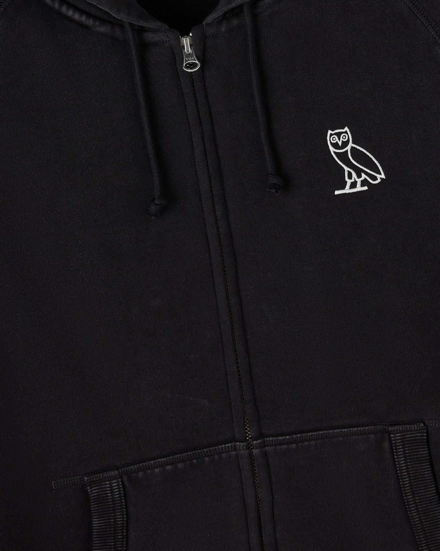 Black full-zip hoodie with white owl embroidery on chest, drawstring hood, and ribbed cuffs.