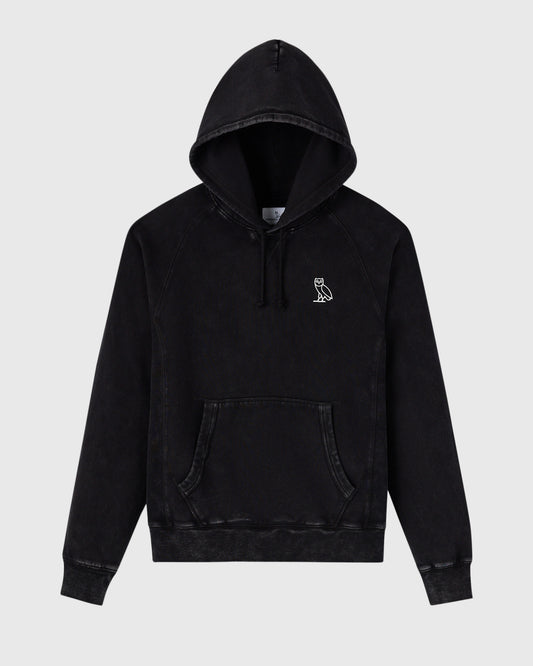Black raglan hoodie with garment-dyed finish, drawstring hood, kangaroo pocket, and small owl embroidery on chest.