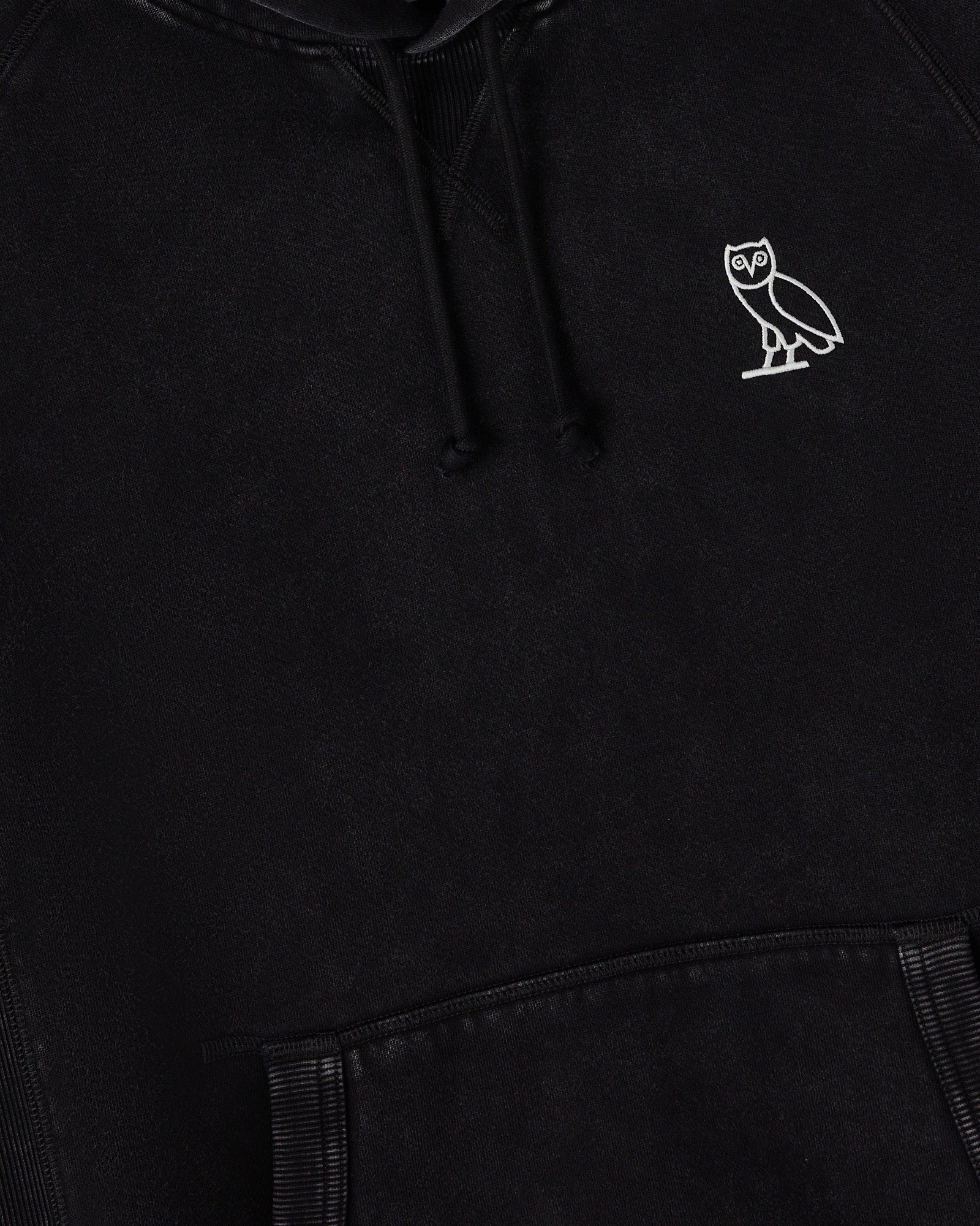 Black raglan hoodie with white owl embroidery on chest and drawstring hood.