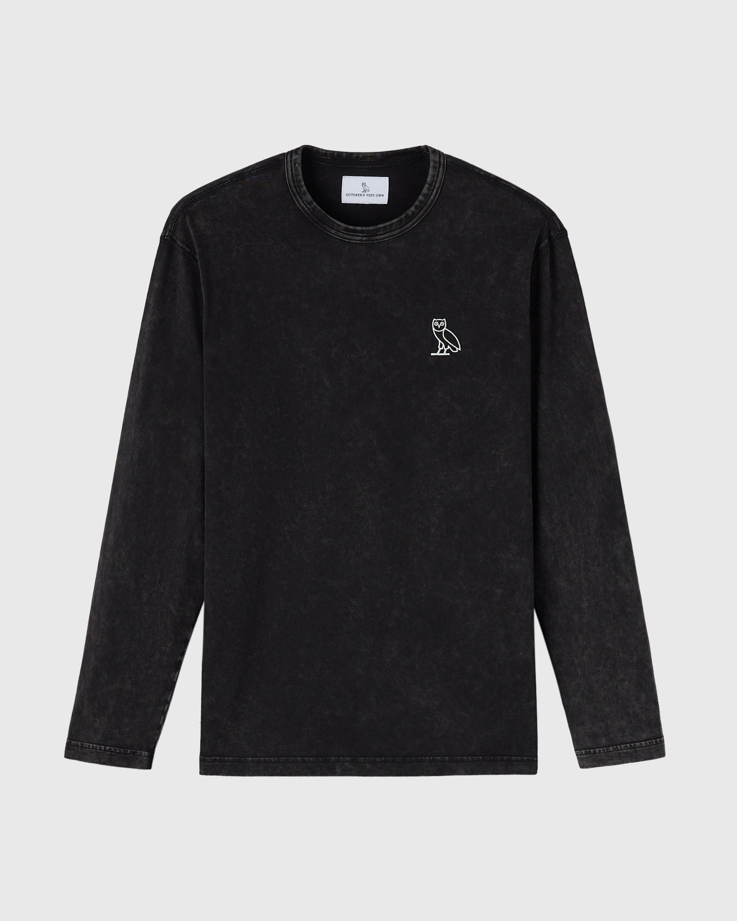 Black garment-dyed long-sleeve tee with small owl embroidery on chest and crew neckline.
