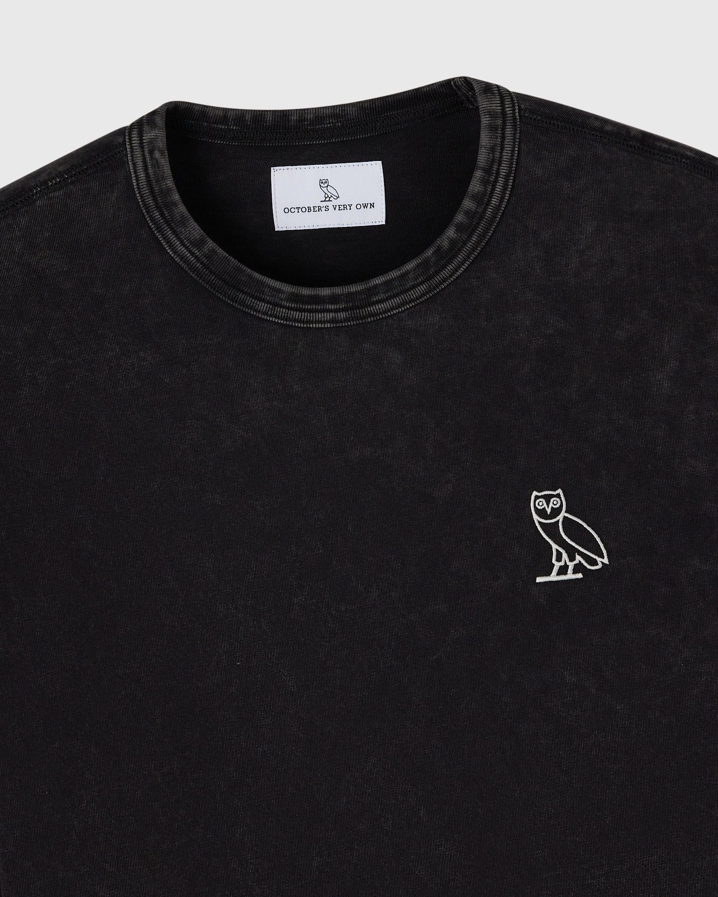Black long-sleeve tee with crew neckline and white owl embroidery on chest.