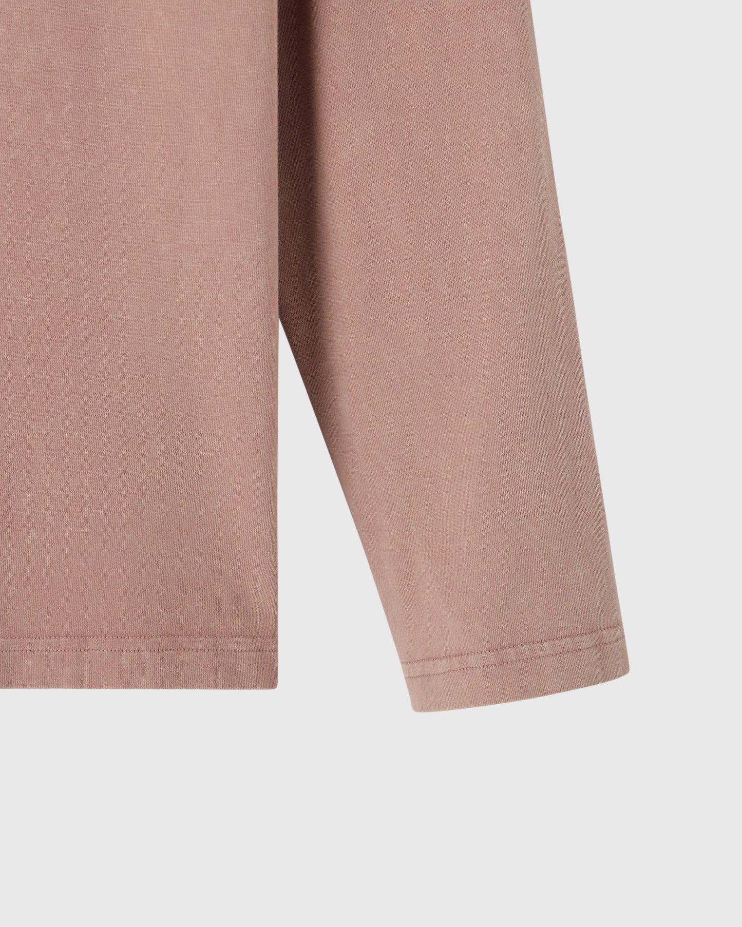 Clay pink long-sleeve tee with ribbed cuffs shown from the side.