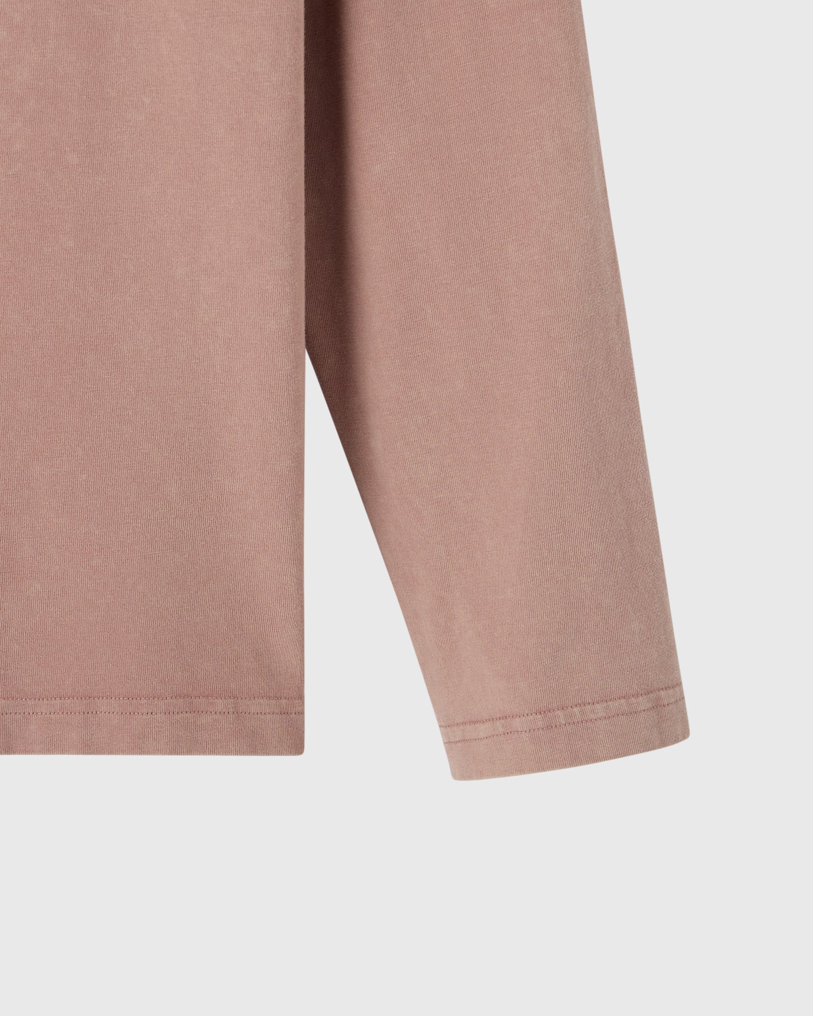 Clay pink long-sleeve tee with ribbed cuffs shown from the side.