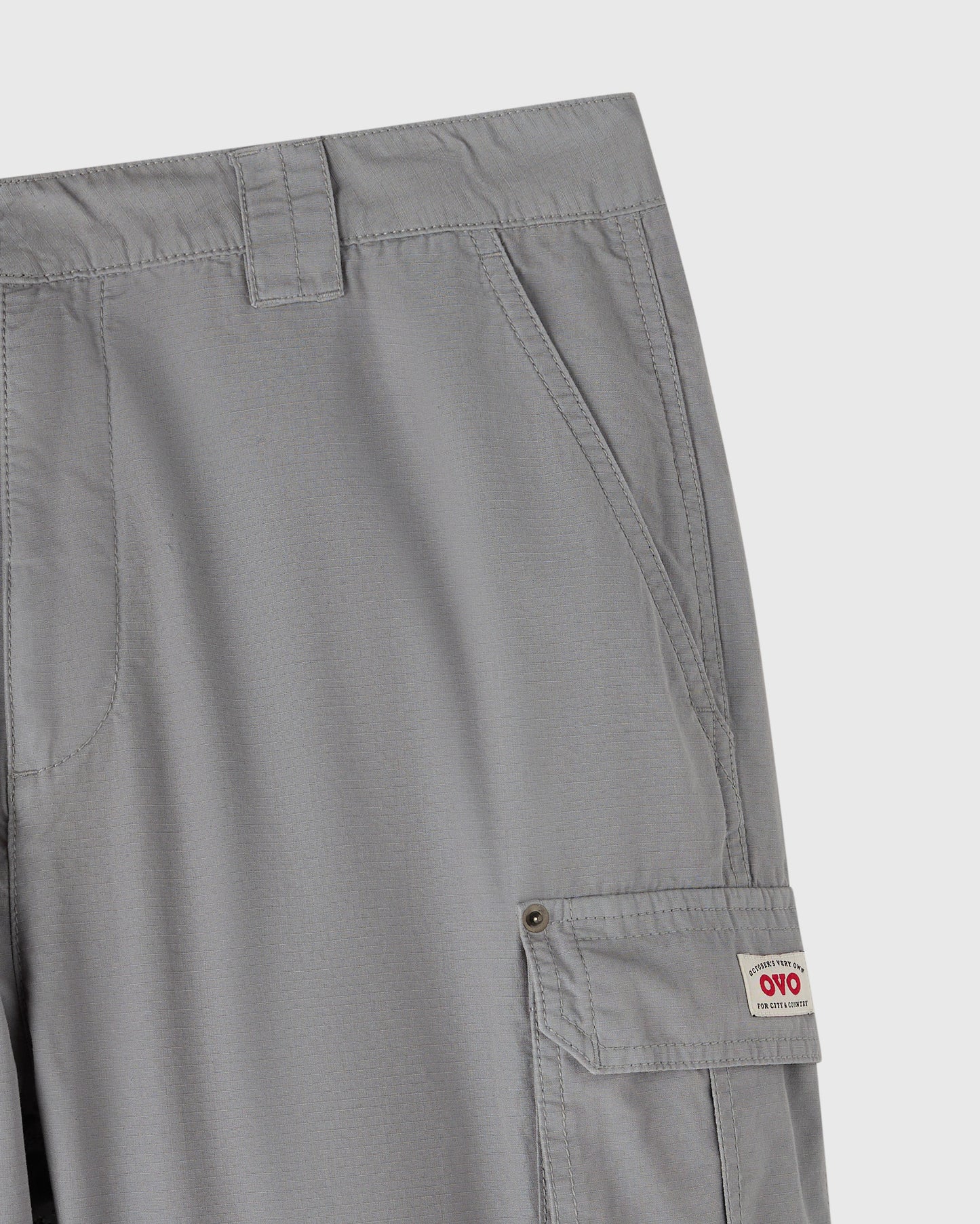 Grey cargo pants with multiple pockets and button closures on the thighs.