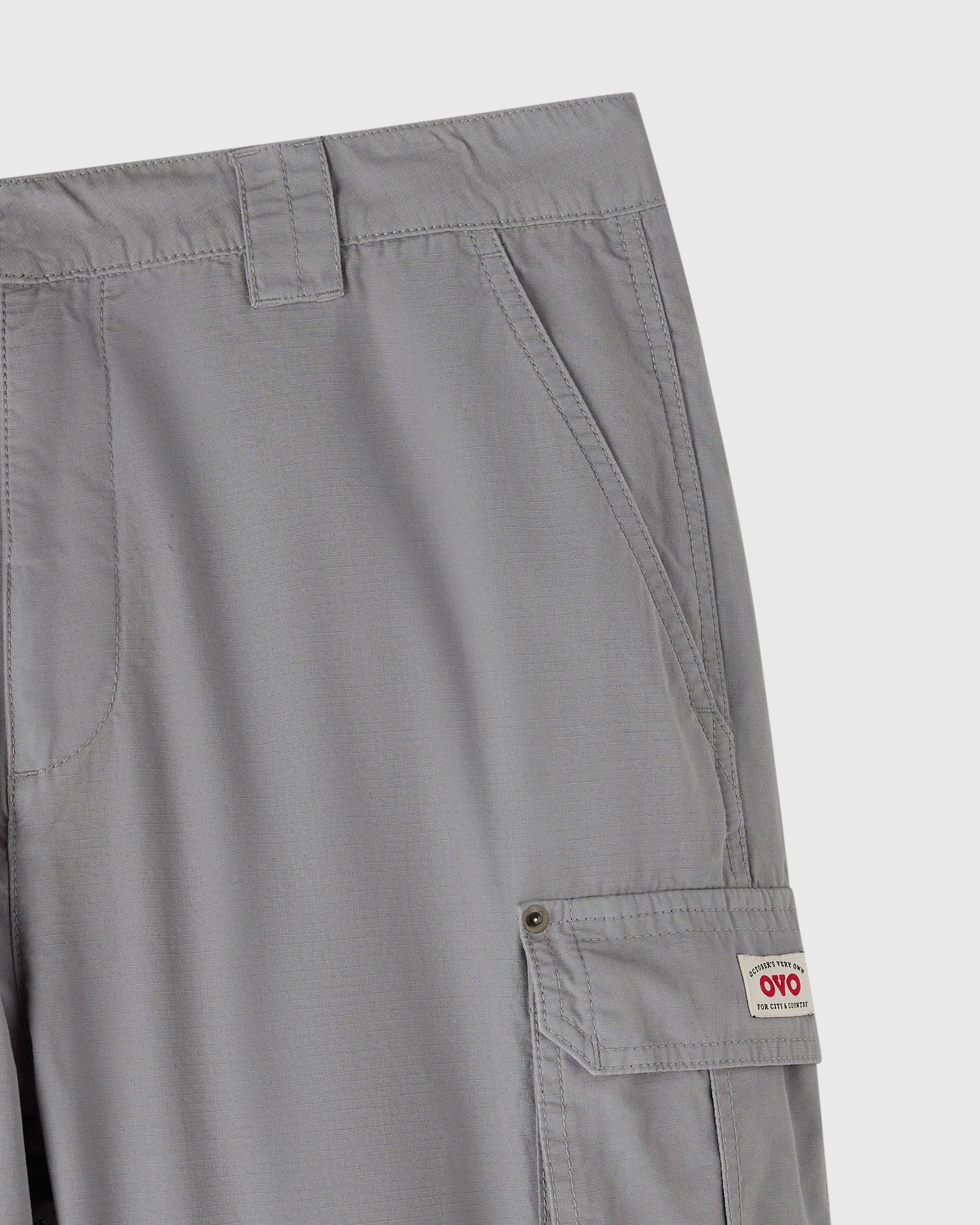 Grey cargo pants with multiple pockets and button closures on the thighs.