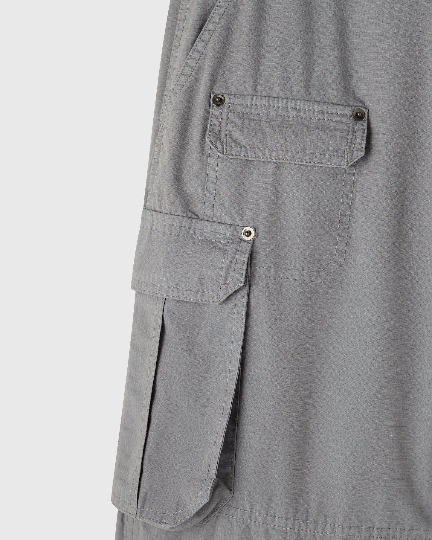 Grey cargo pants with multiple buttoned pockets on the thighs and side panels.