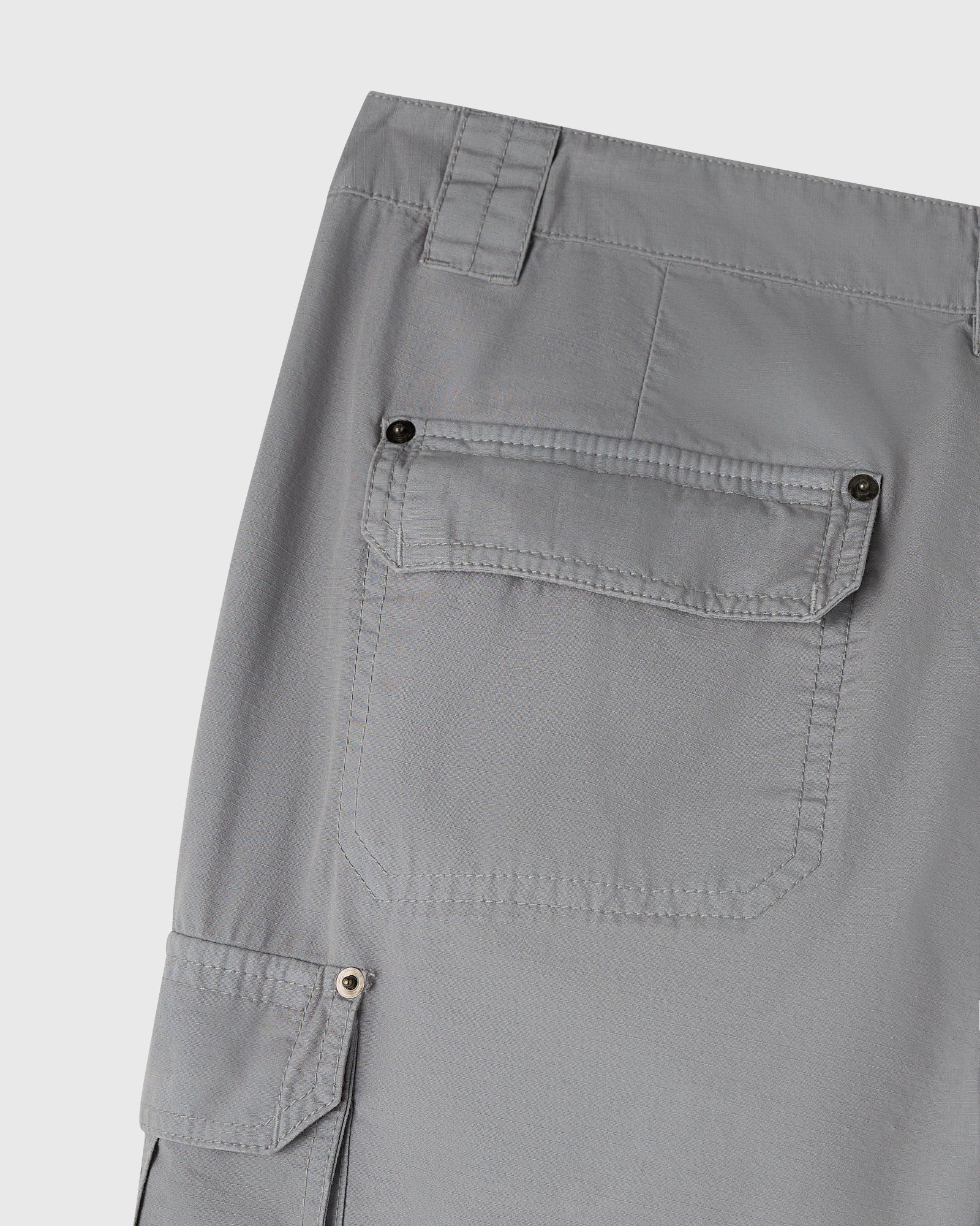 Grey cargo pants with multiple button-flap pockets on thigh and hip areas.