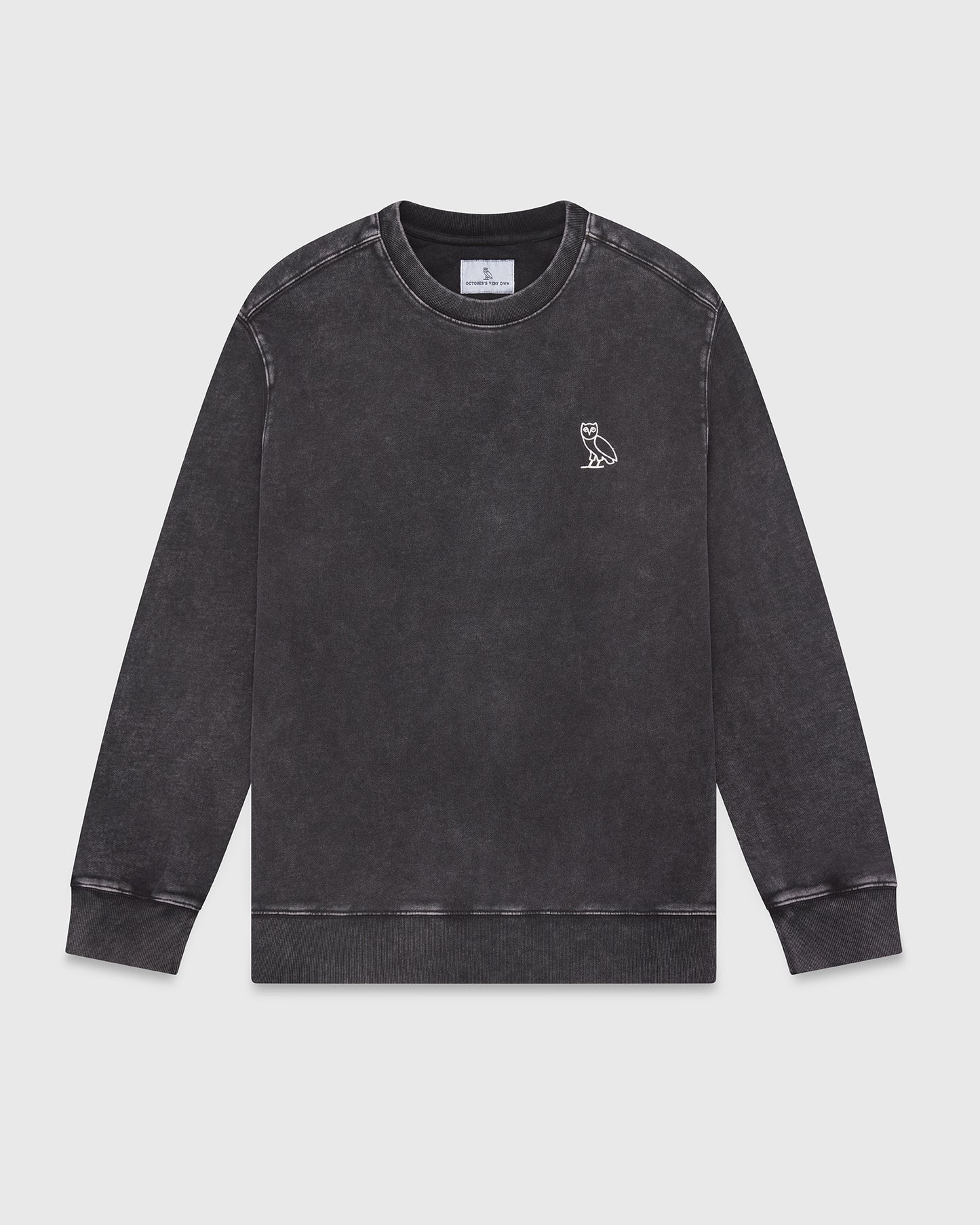 Black garment-dyed crewneck sweatshirt with small owl embroidery on chest and ribbed cuffs.