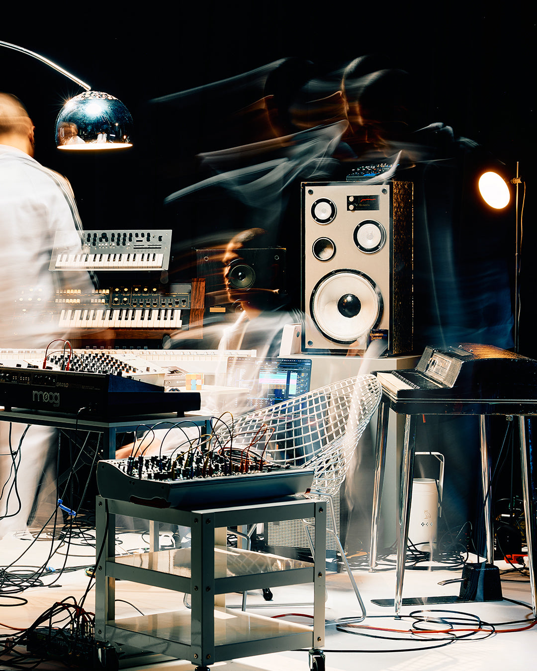 Music studio with electronic equipment and people in the background