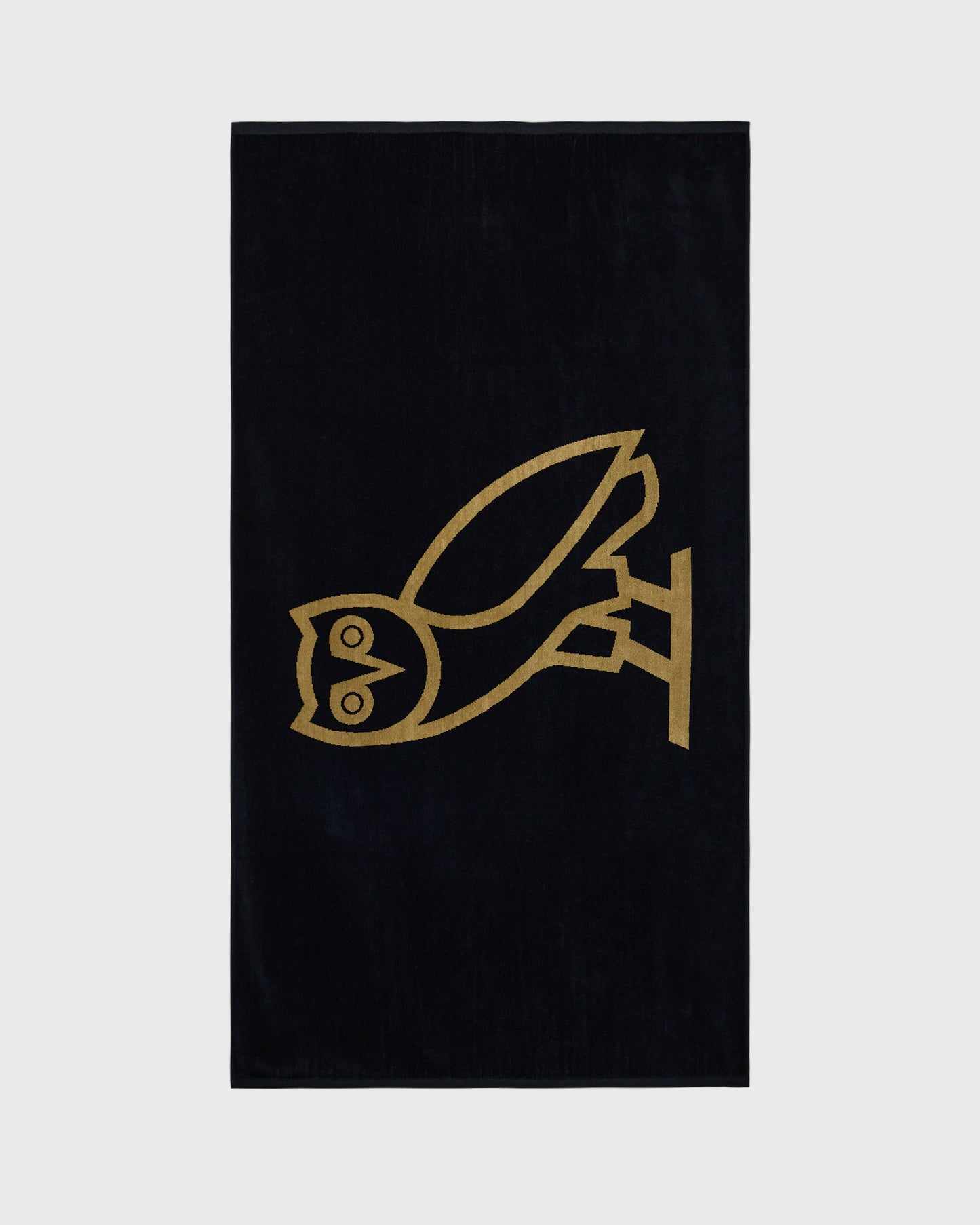 Black towel with gold line-drawn bird design in center.