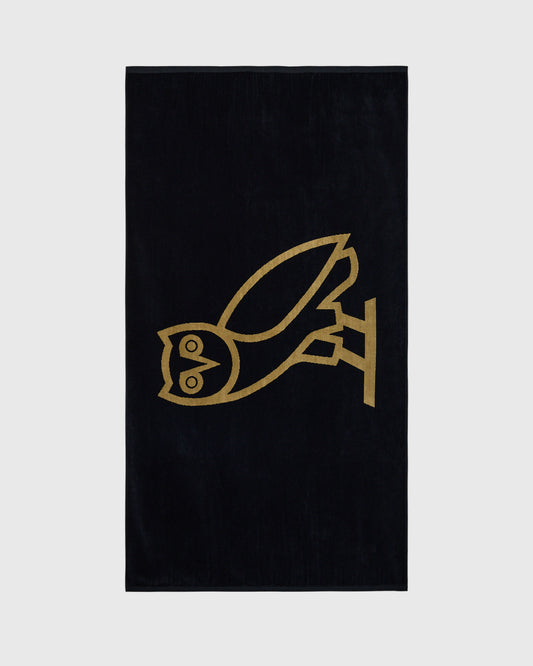 Black towel with gold line-drawn bird design in center.