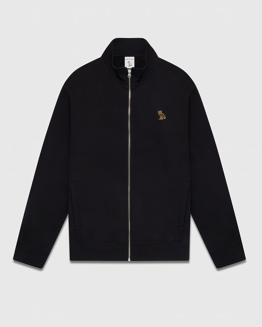 Black full-zip track jacket with small gold owl embroidered on chest and front pockets.