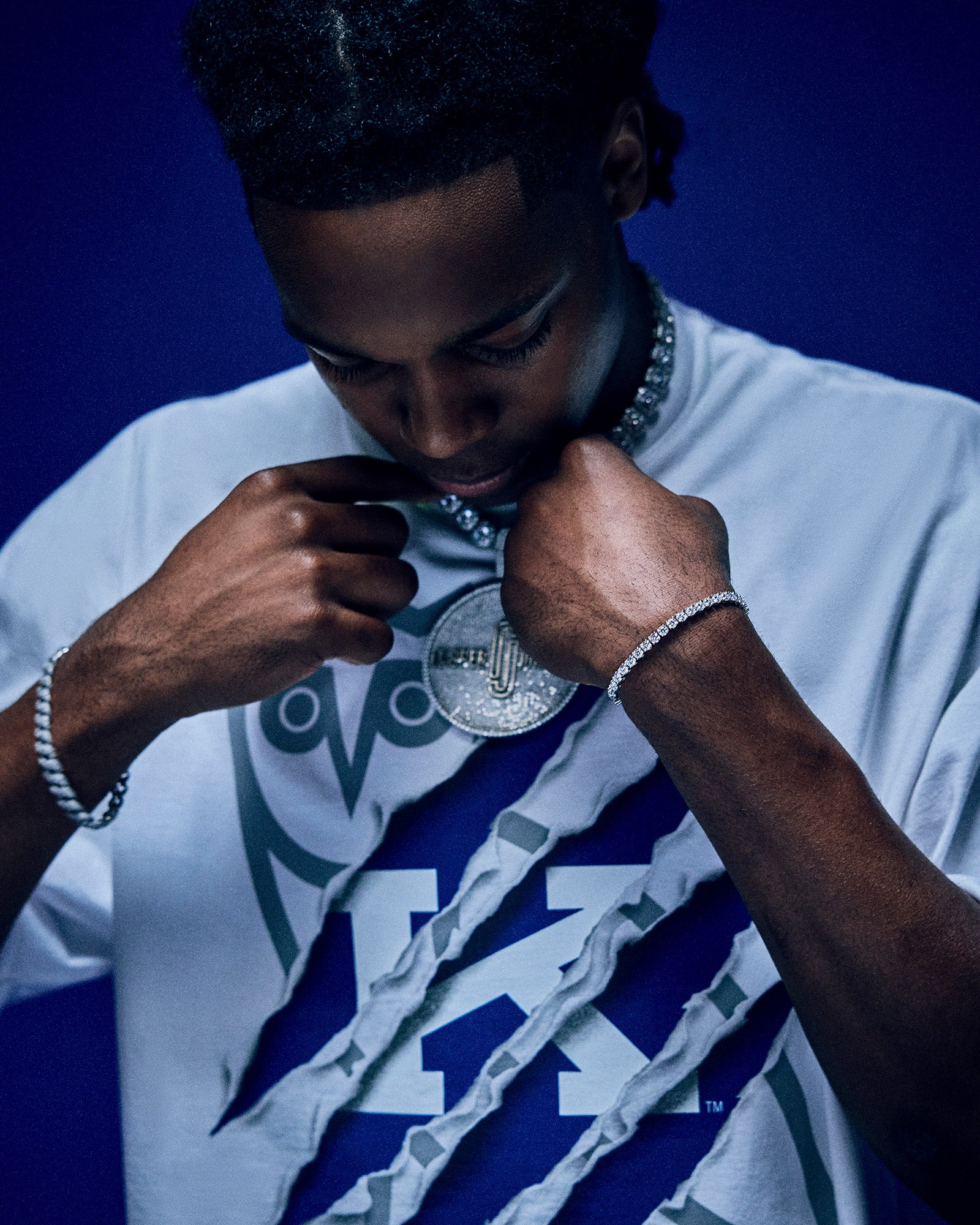 Person holding a silver medal close to their face against a dark background