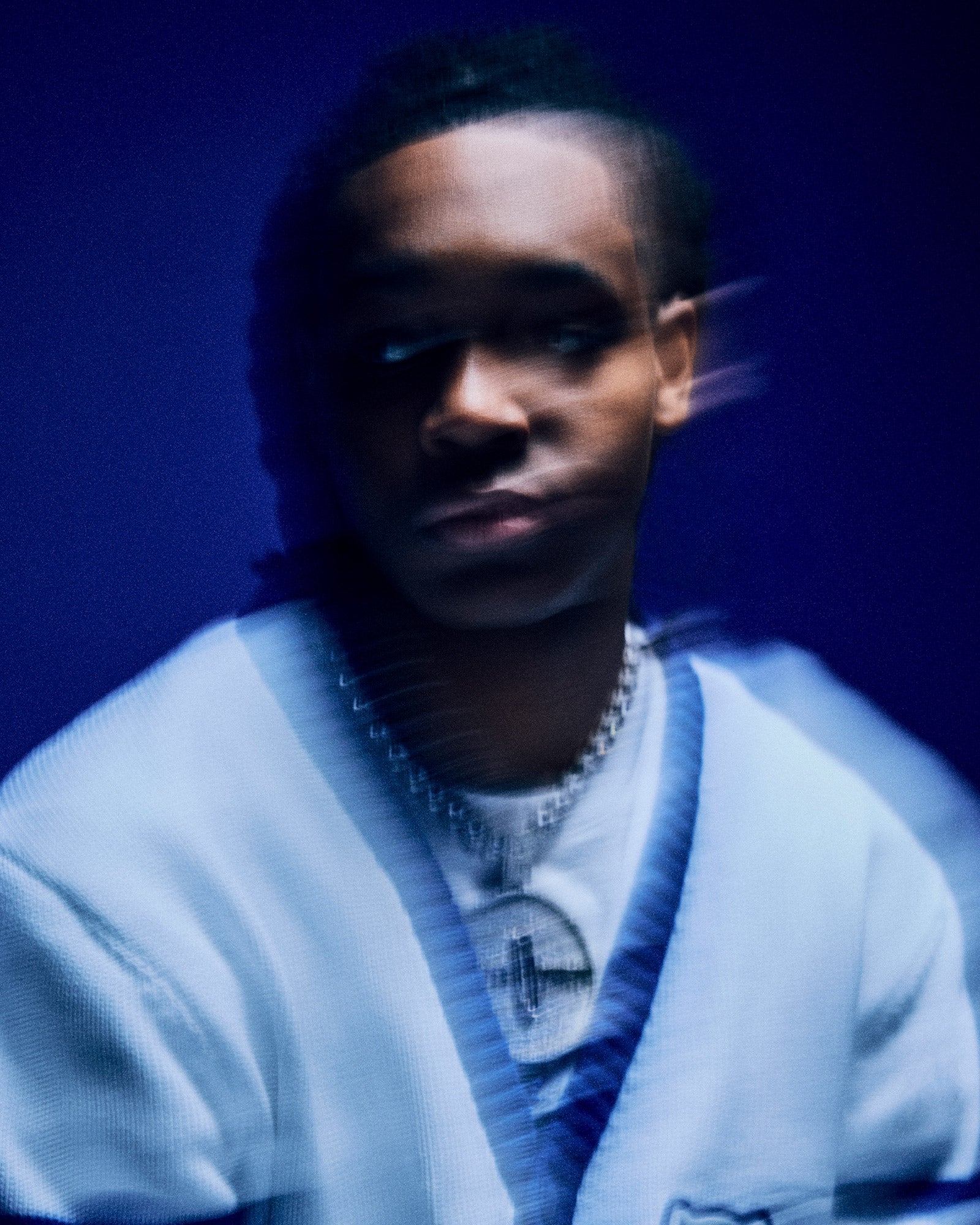 Person wearing a white October's Very Own x Kentucky Wildcats sweater with a blue gradient background