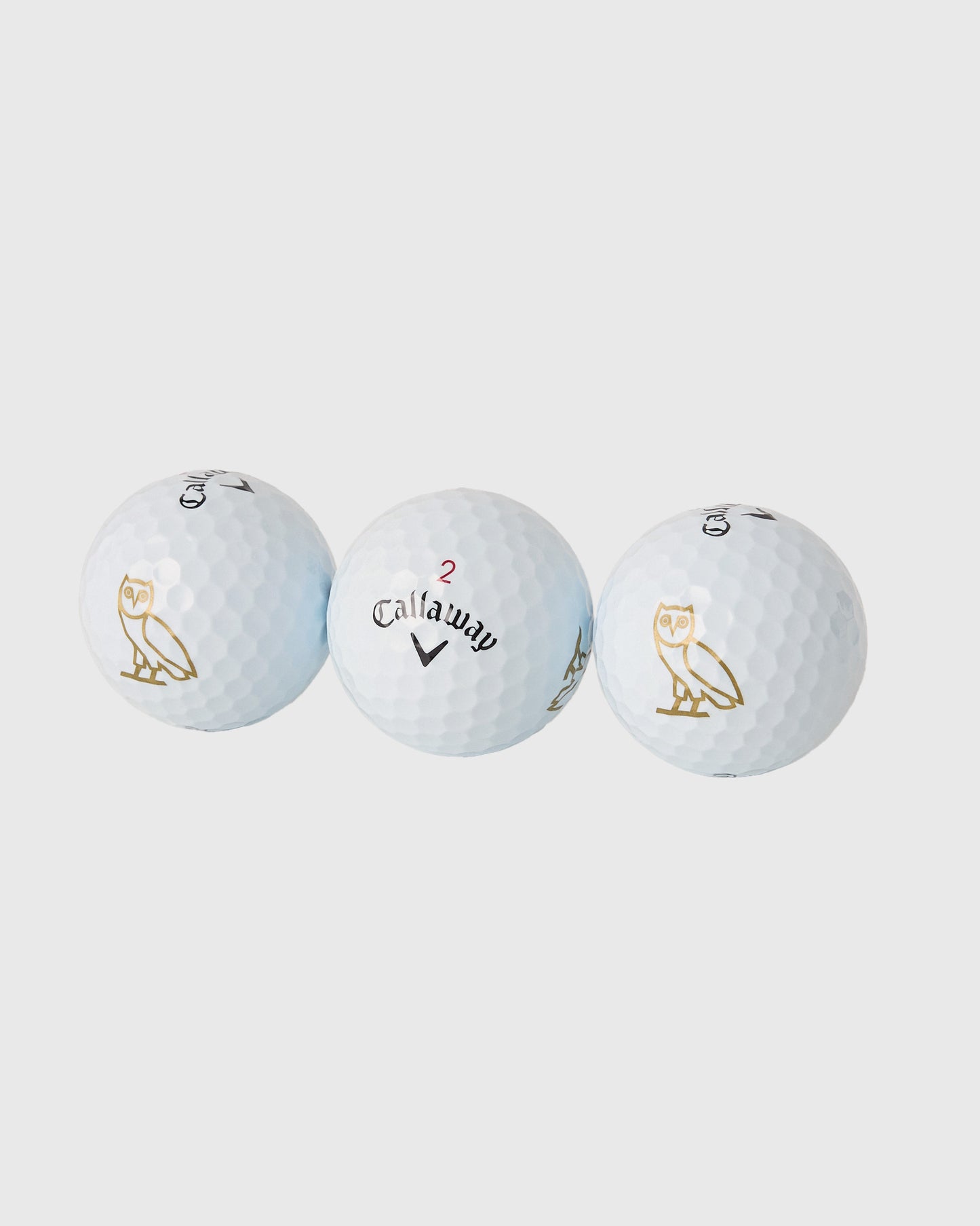 Three white Callaway Chrome Tour golf balls with dimple pattern, displaying triple diamond marking and gold owl logo.