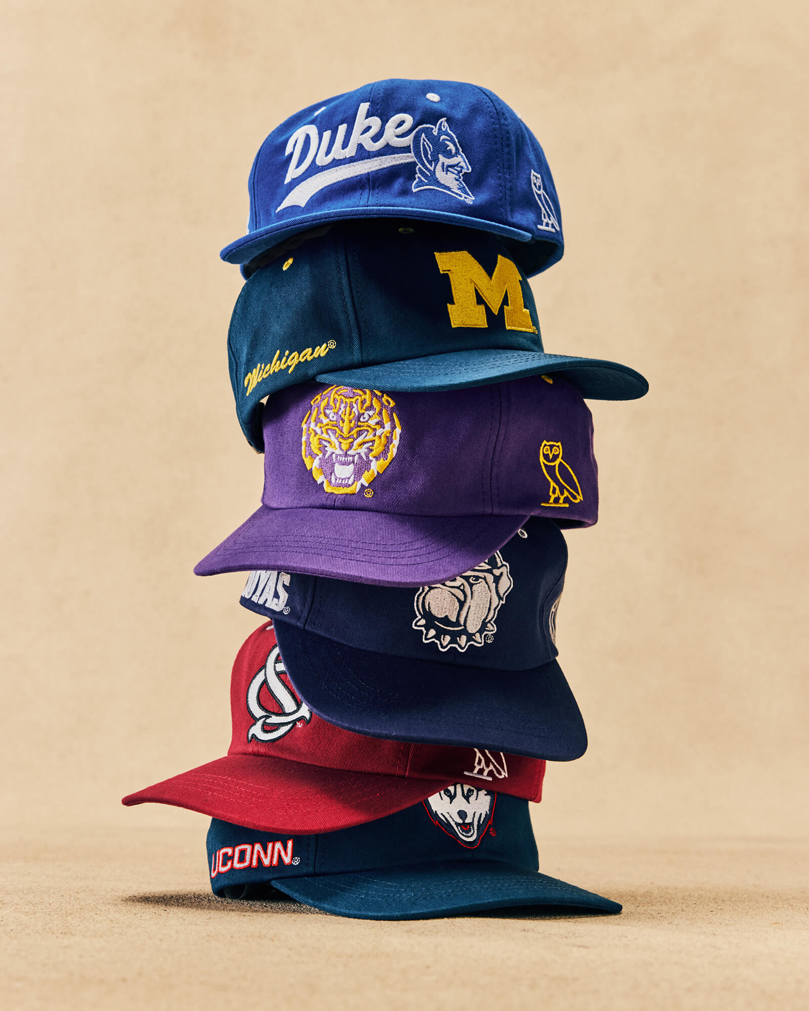 stack of October's Very Own x College Basketball hat's