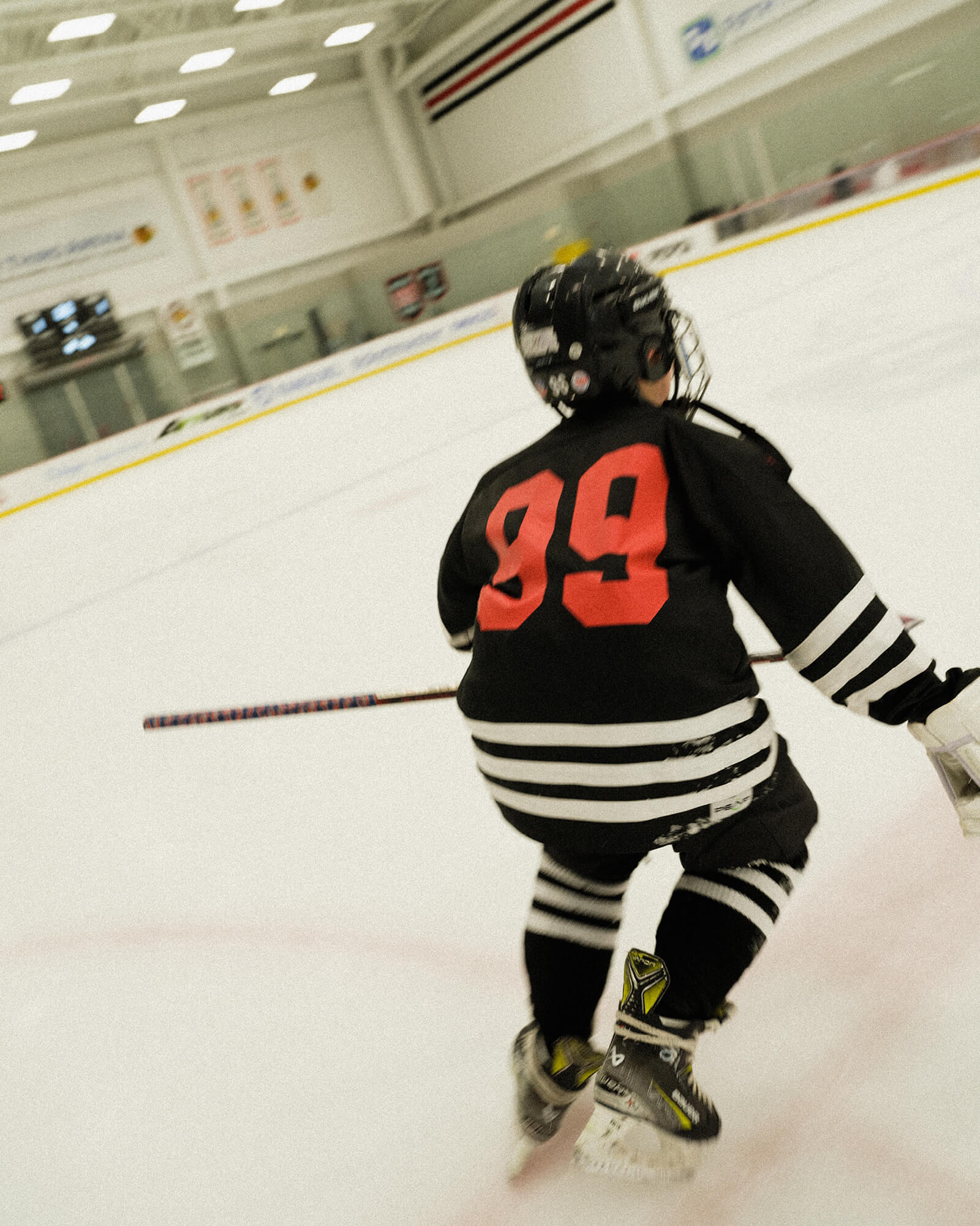 Person in a hockey uniform with the number 89 on an indoor ice rink