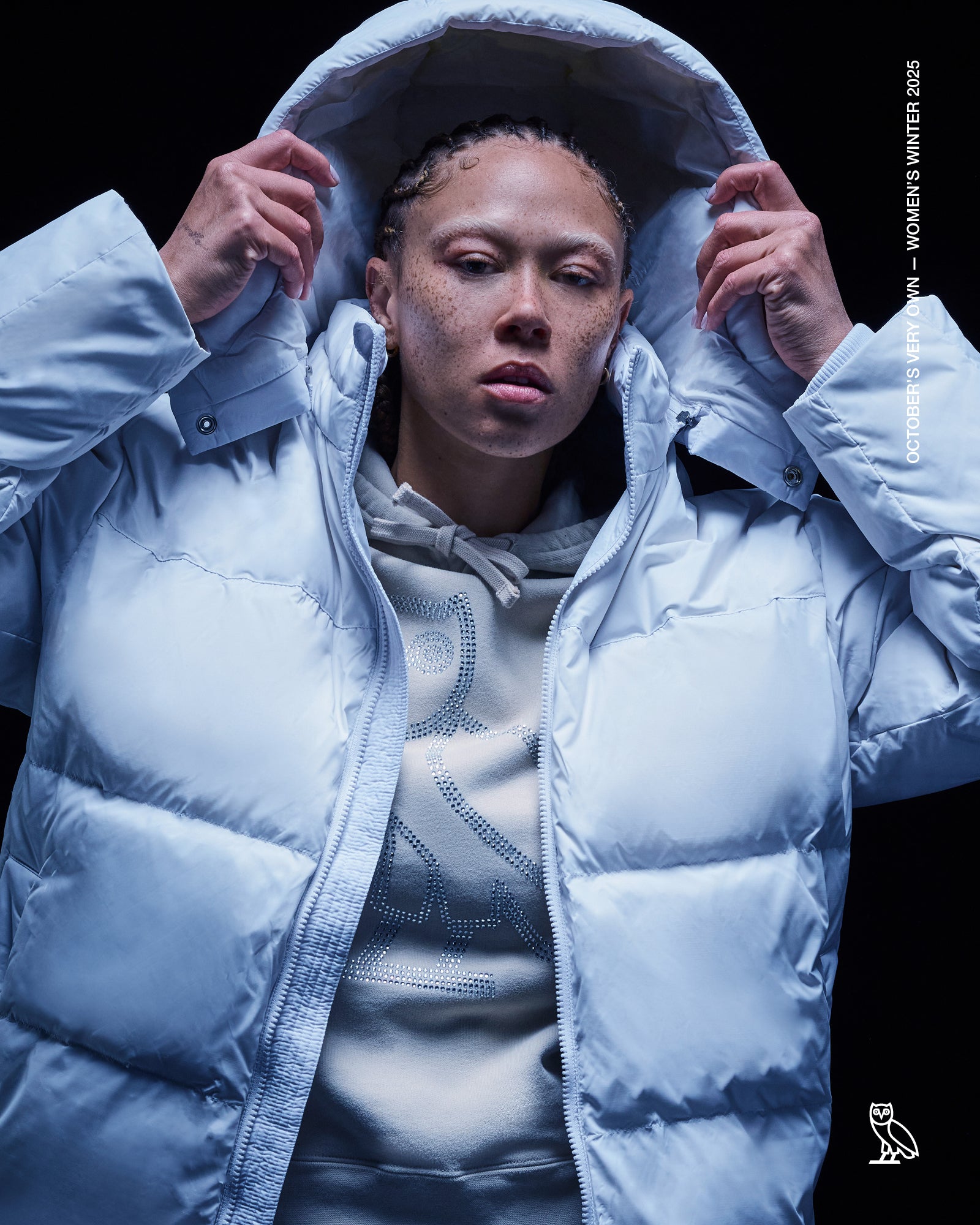 Person wearing a October's Very Own light blue puffer jacket with a dark background