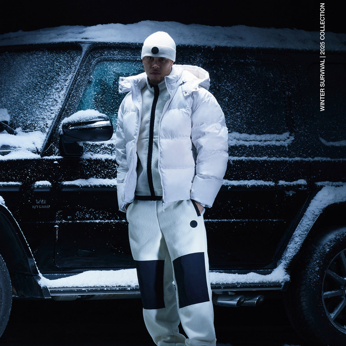 Person standing in front of car wearing clothing from the winter survival collection