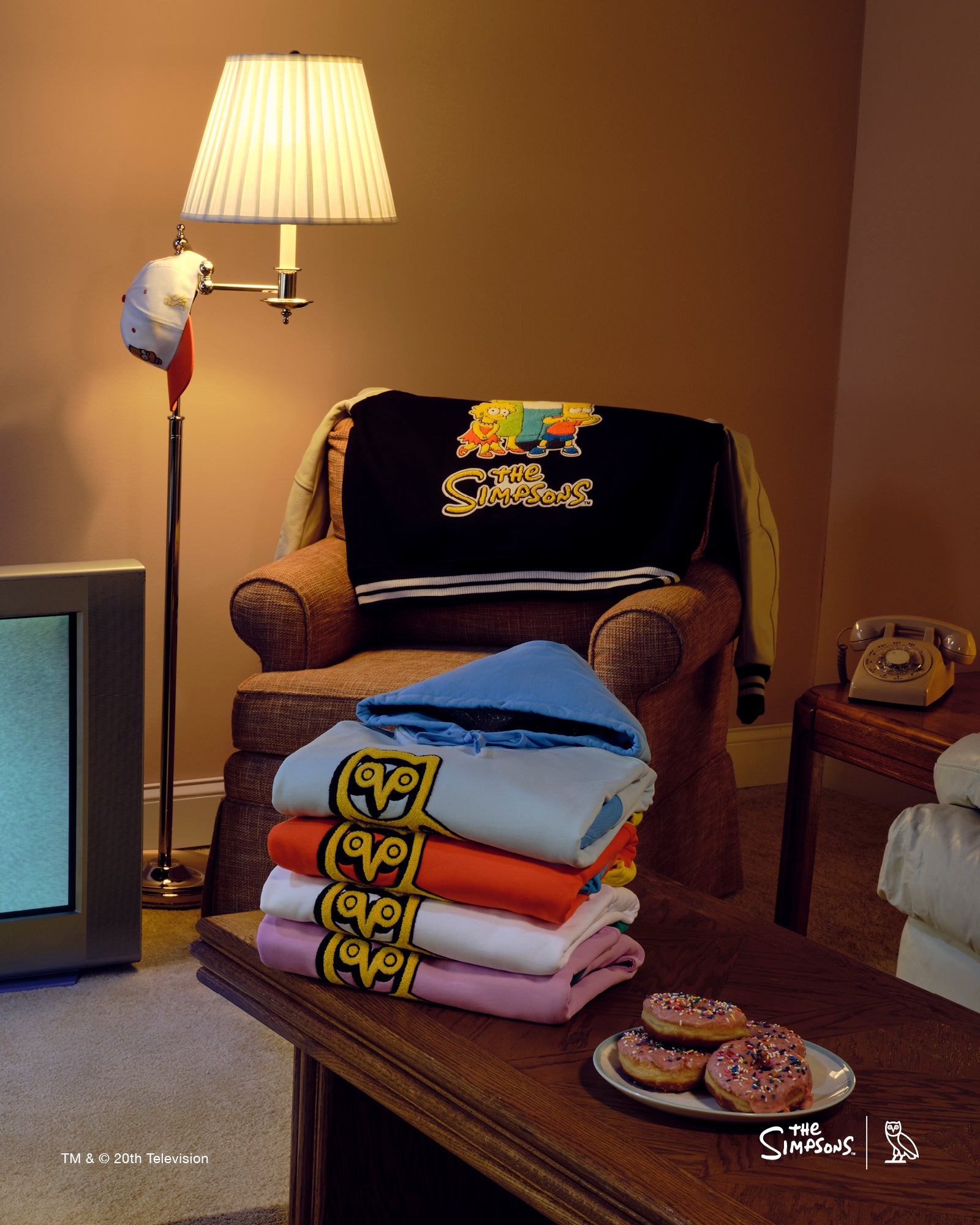 Living room with October's Very Own x The Simpsons on a chair and table, and a lamp in the background.