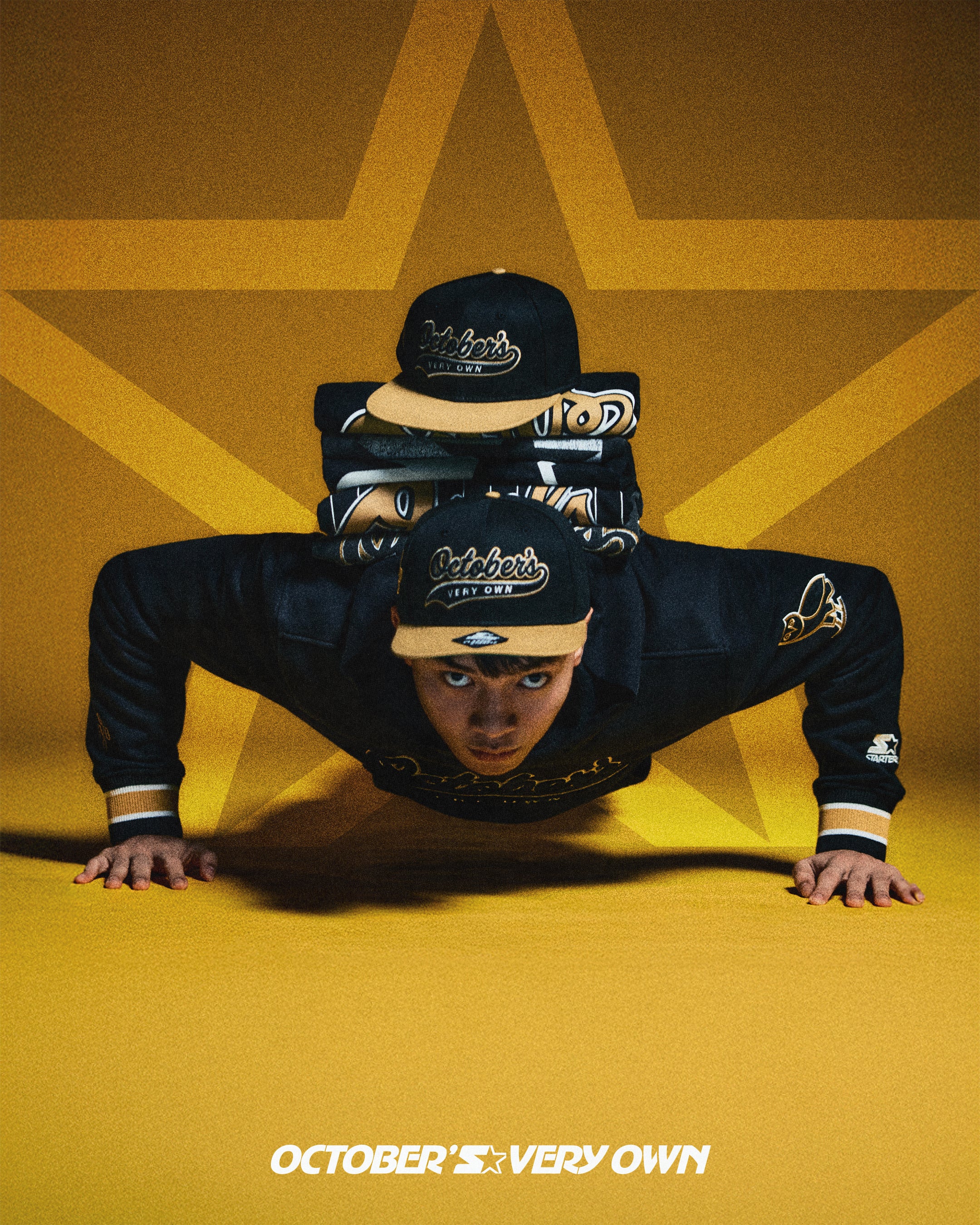 Person wearing a black outfit with a cap, lying on a yellow star-shaped background with 'October's Very Own' text.