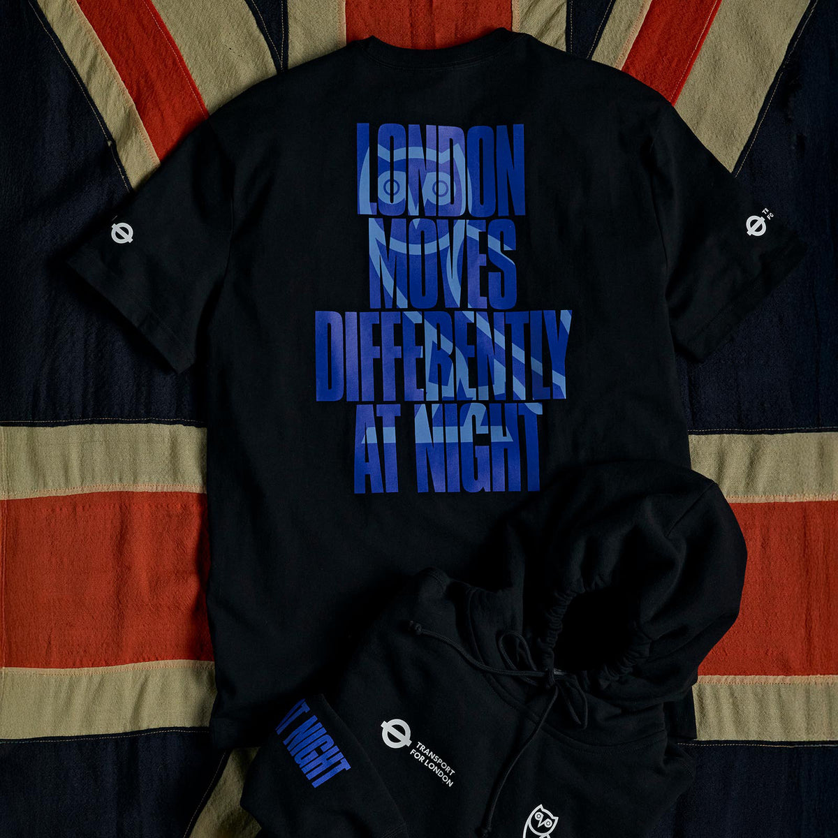 London Moves differently October's Very Own and TFL T-shirt and Hooded sweatshirt, on top of a British Flag