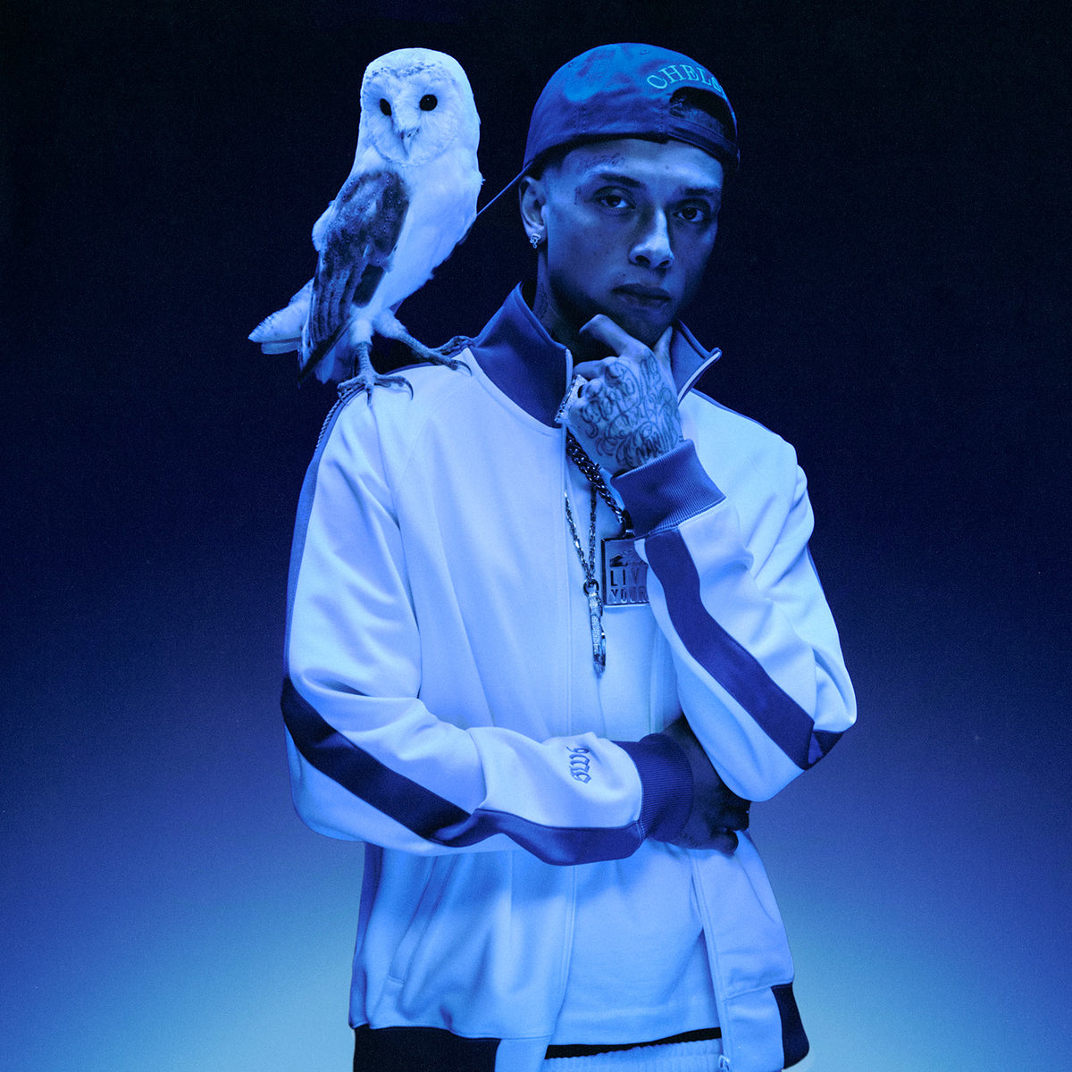 Central Cee with an owl on his shoulder wearing the October's Very Own x Chelsea Collection