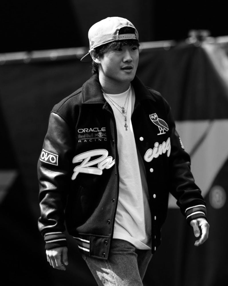 Yuki Tsunoda wearing a October's Very Own x Red Bull Racing Varsity Jacket