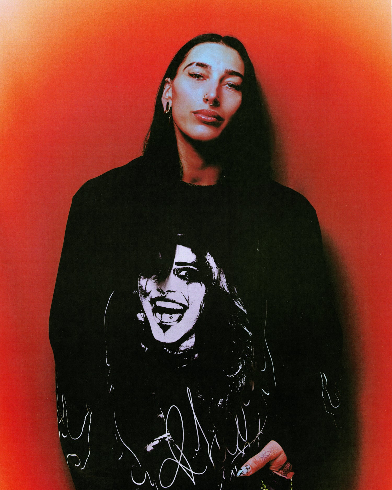 Rhea Ripley wearing a black October's Very Own x WWE Longsleeve with a graphic design on a red background