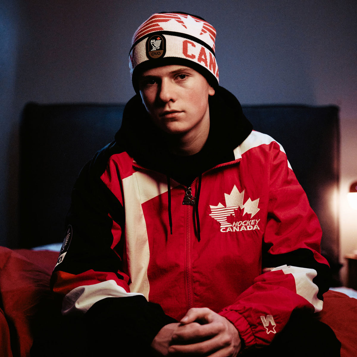 Person wearing a red and white hockey-themed jacket with 'Canada' text and a maple leaf emblem. October's Very Own and Hockey Canada.